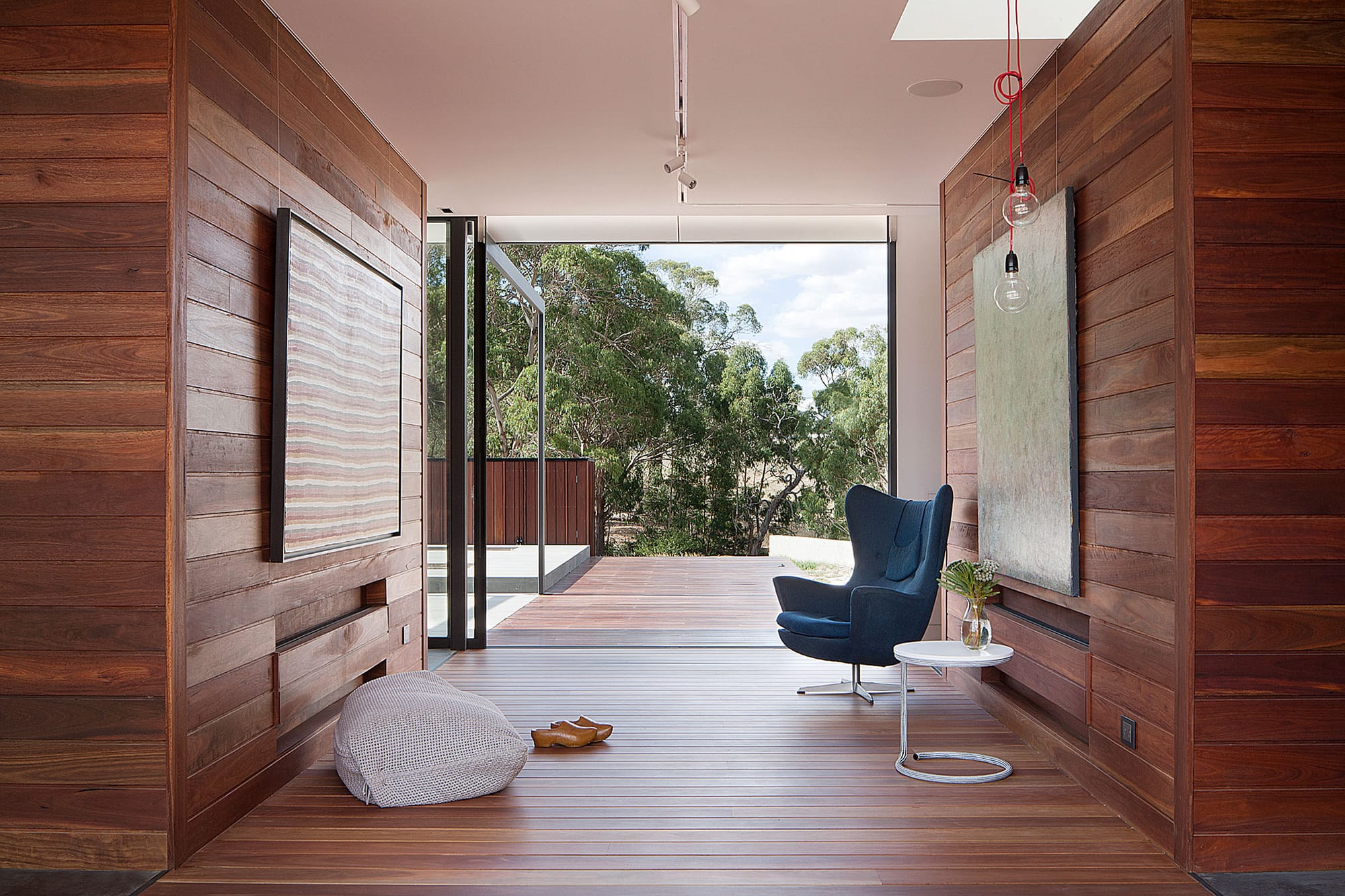 Piermont Jacksons Road by Rachcoff Vella Architecture. Photography by Lean Timms. Interior courtyard with timber walls and floors, and sliding glass walls opening on timber deck and native bushland. 