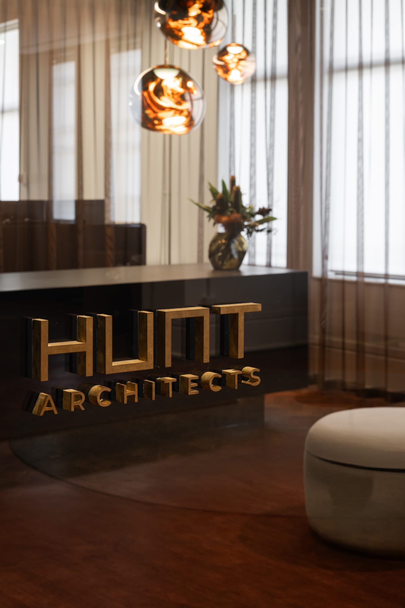 Hunt Architects Perth Studio. Photography by Dion Robeson. Gold 3D font on black gloss reception desk .