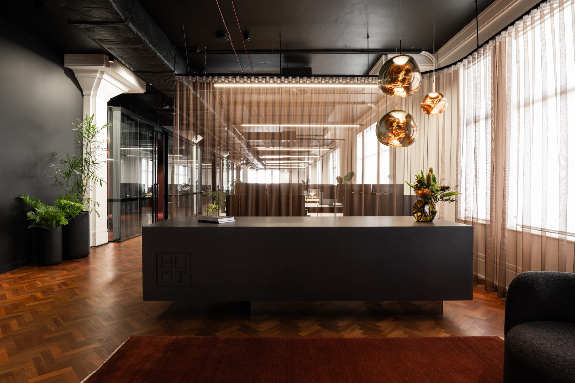 Hunt Architects Perth Studio. Photography by Dion Robeson. Dark reception in office, in front of sheer curtains and on timber herringbone floors.