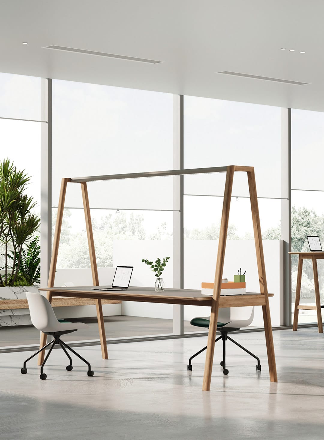 Bazar Table by UFOU. Timber work desk with angled legs and conical design in office space with concrete floors, full length windows and white office chairs. 