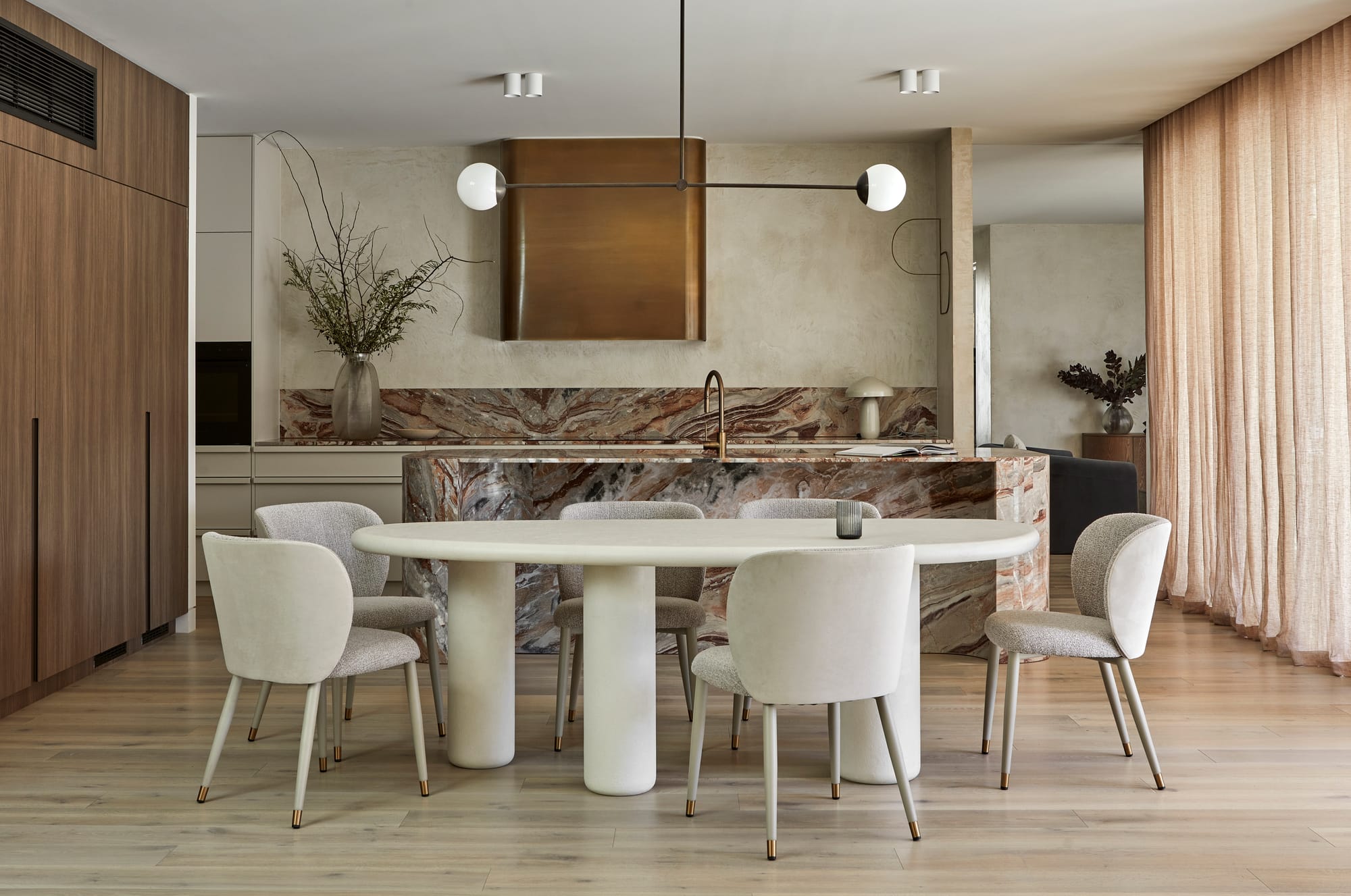 GlobeWest Collection 2025.  Dining space with grey tiled floors and rammed earth walls.