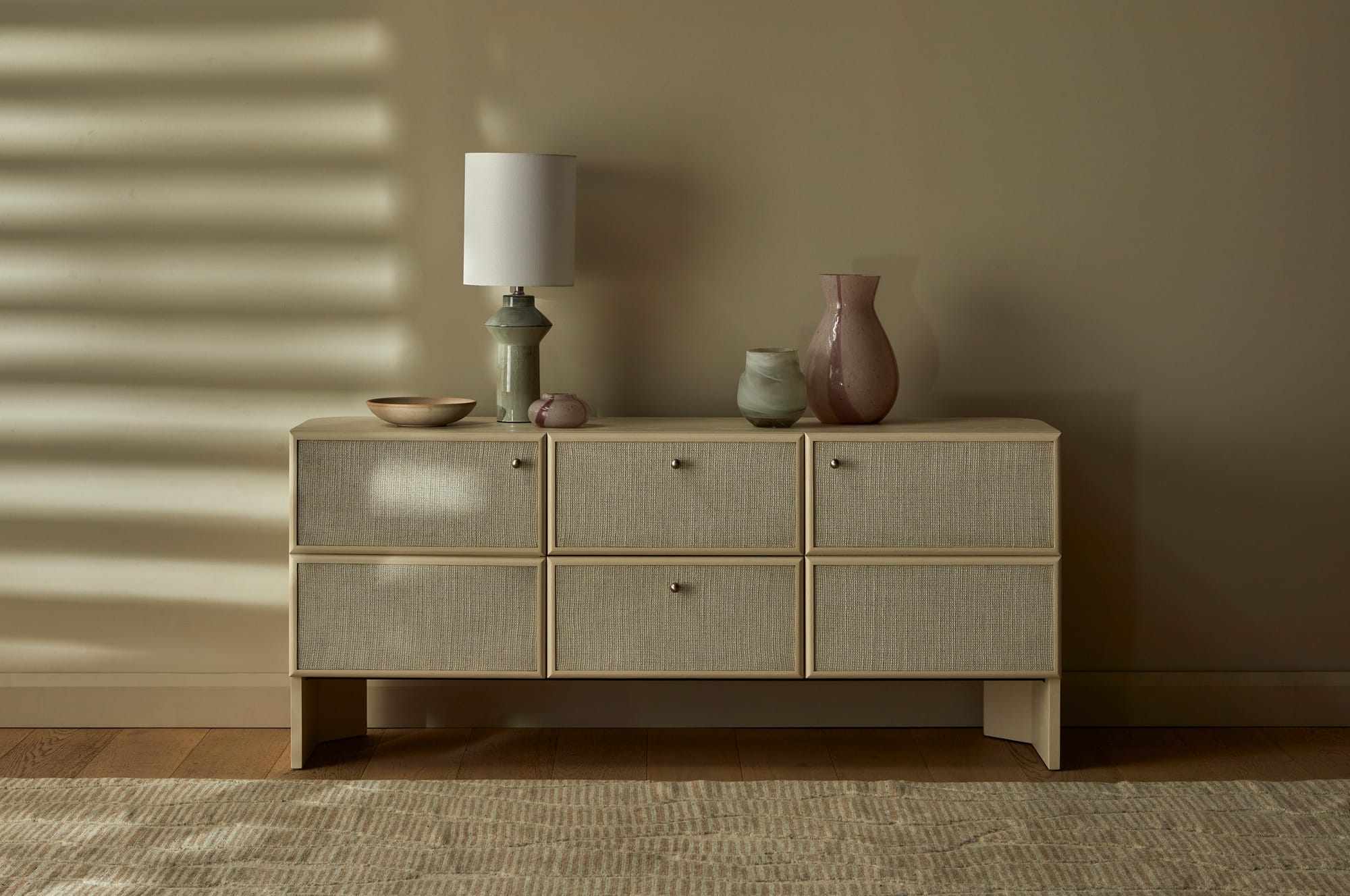 Elodie by GlobeWest from Collection 2025. Timber and rattan sideboard on timber flooring in front of beige walls. 