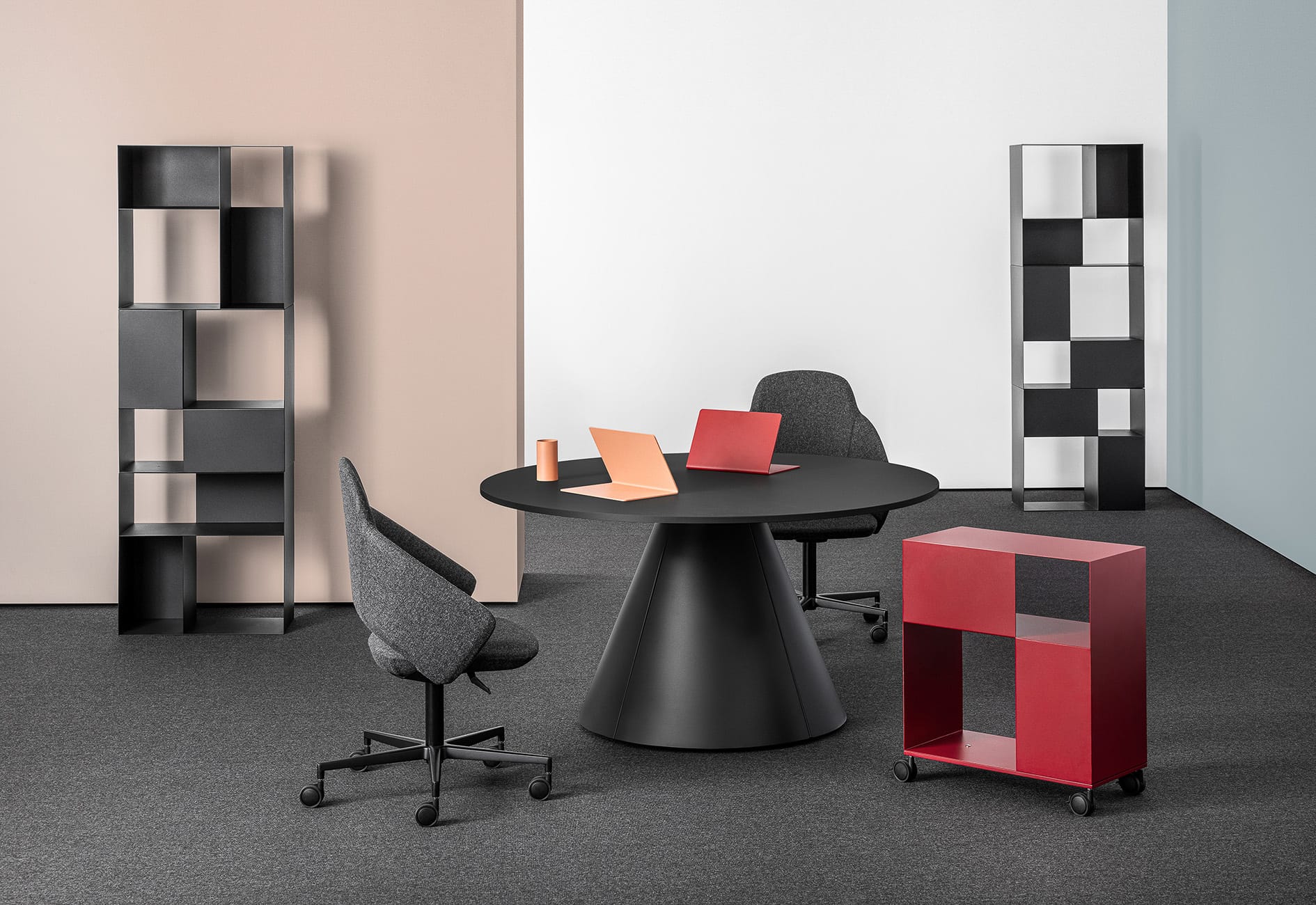 Follow Meeting Table by Mara SRL. Black cone-shaped table with two dark grey office chairs in office space with various storage units. 