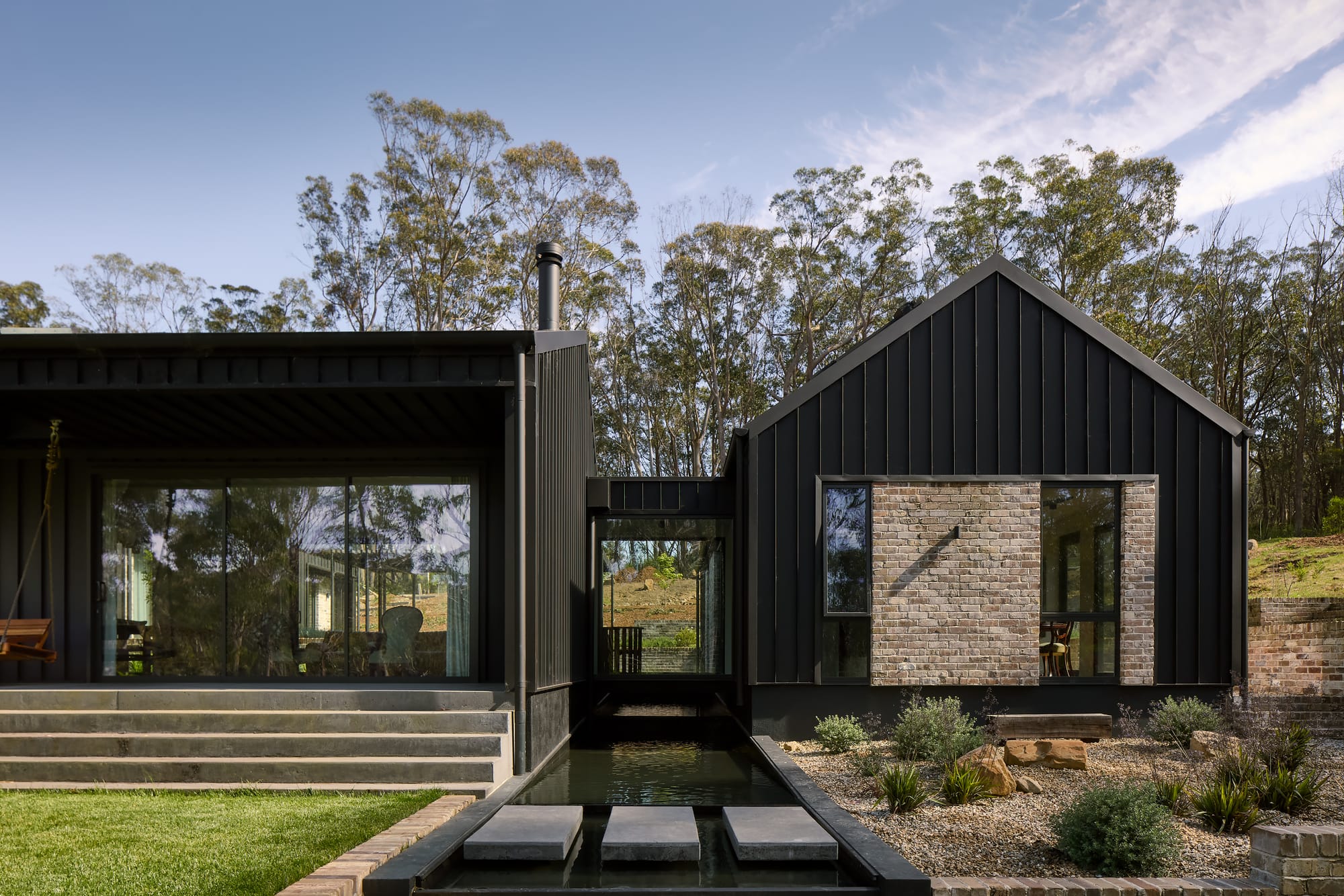 House Kimberley by AO Design Studio. Photography by Luc Remond. Timber door on black clad.