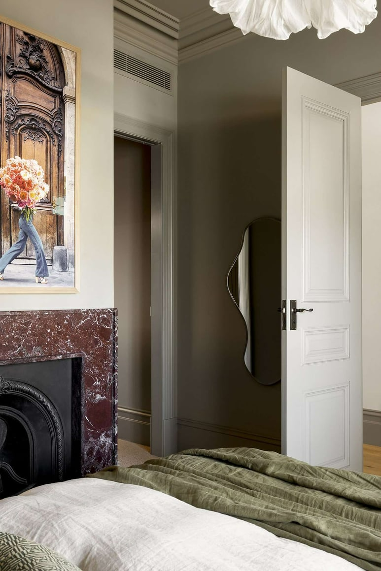 Albert Park Residence by FURNISHD. Photography by Dylan James. Bedroom with moss green walls, burgundy marble fireplace, heritage fixtures and white bedding.