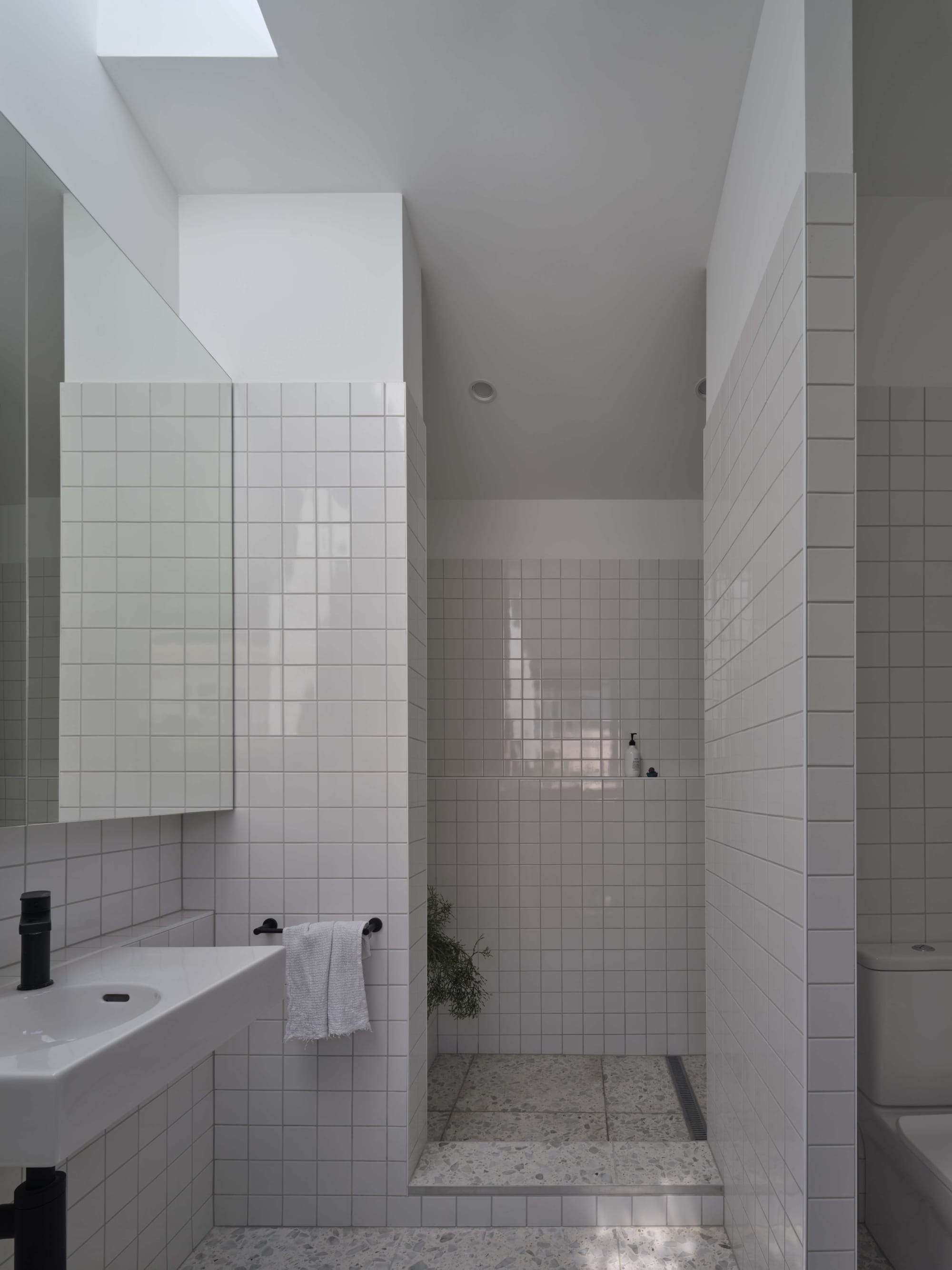 Blok Peregian by Blok Modular. Photography by Christopher Frederick Jones. White tiled bathroom with wet room, white vanity and box mirror.