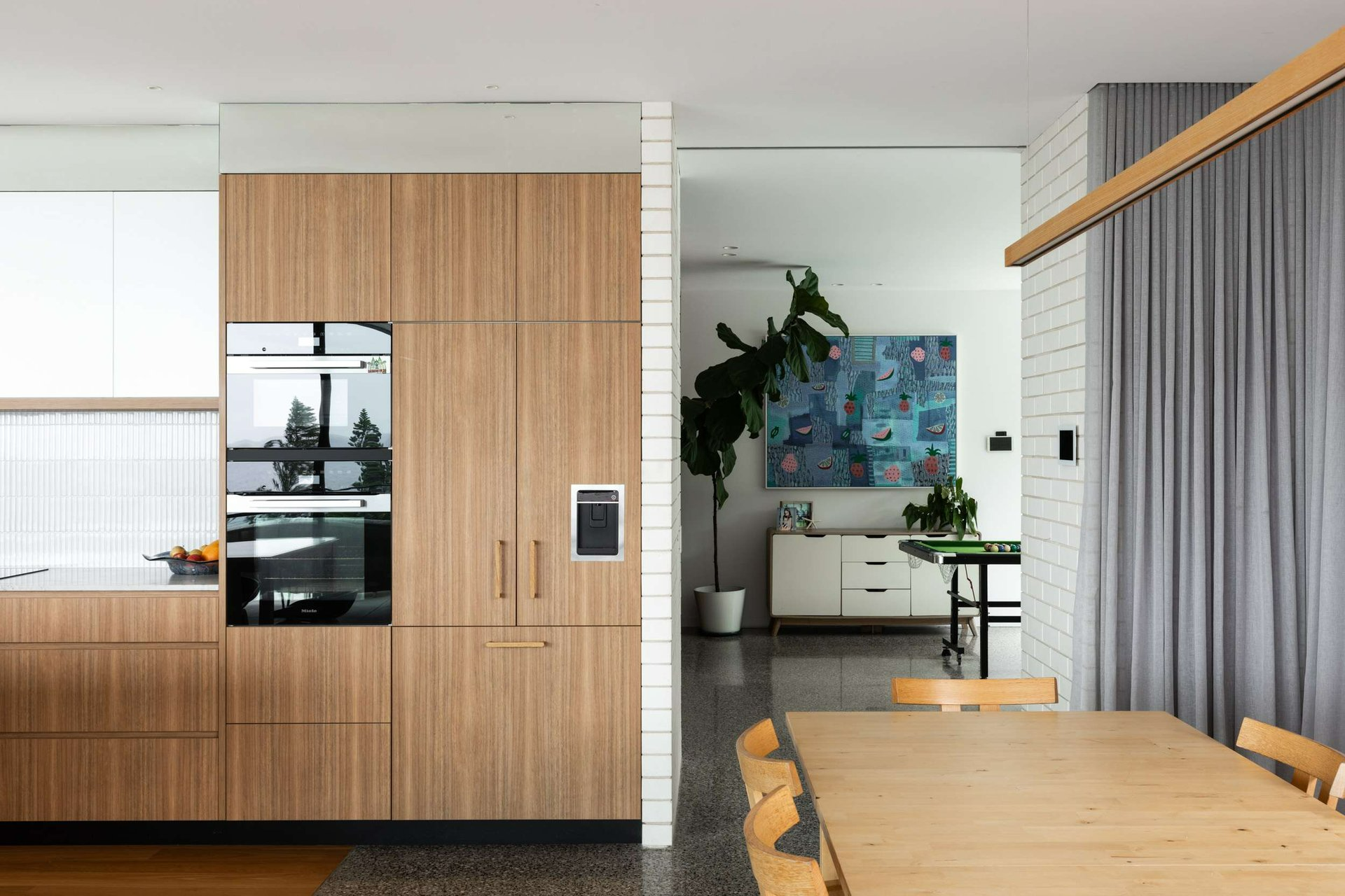 Curl Curl 05 by Watershed Architects. Photography by Simon Whitbread. Kitchen with integrated timer-faced refrigerator, ovens and water dispenser.