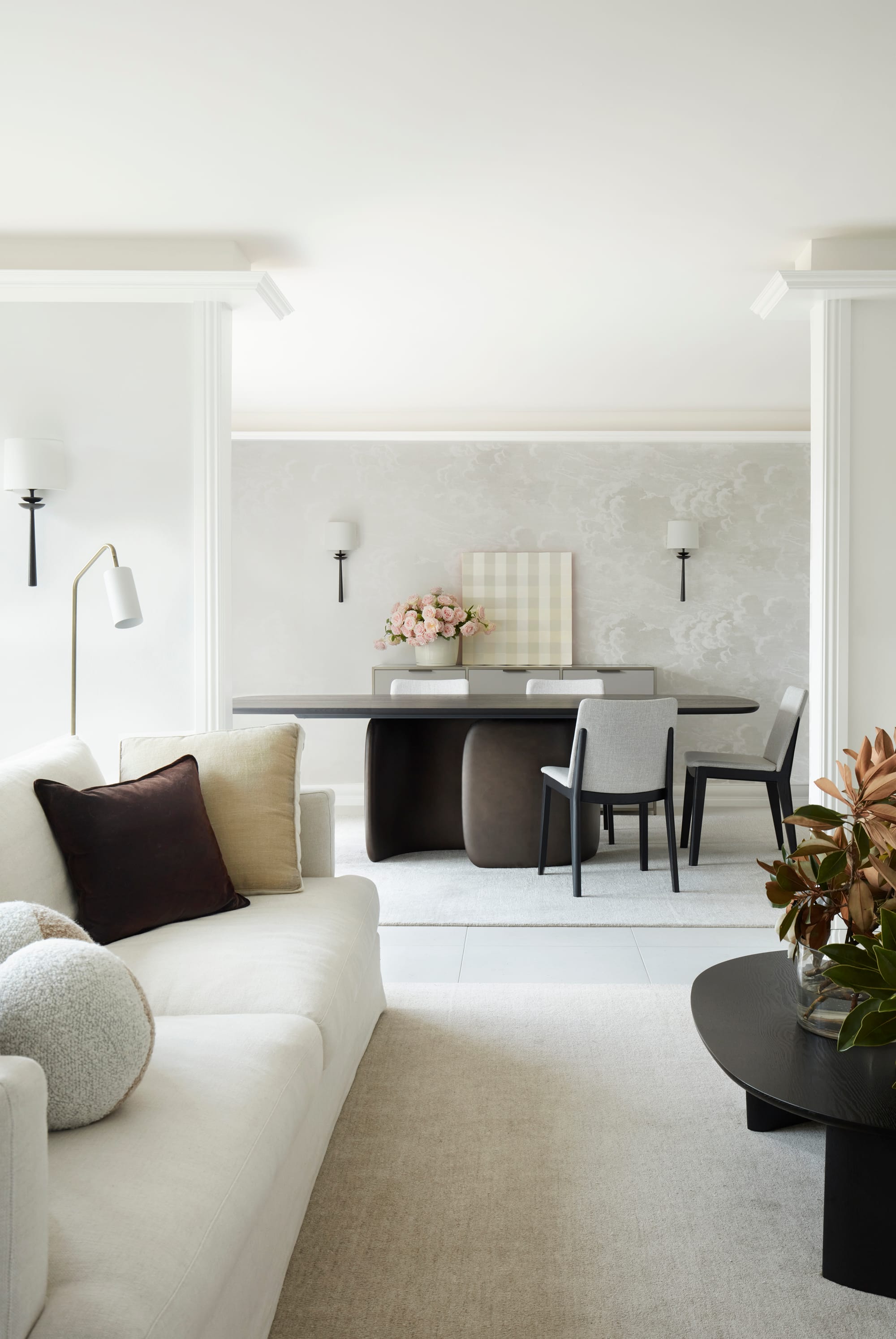 Marathon Road by Marylou Sobel Interior Design. Photography by Prue Ruscoe. Living and dining room space with white couch, light carpet, rugs and tile flooring and large sculptural timber dining table.