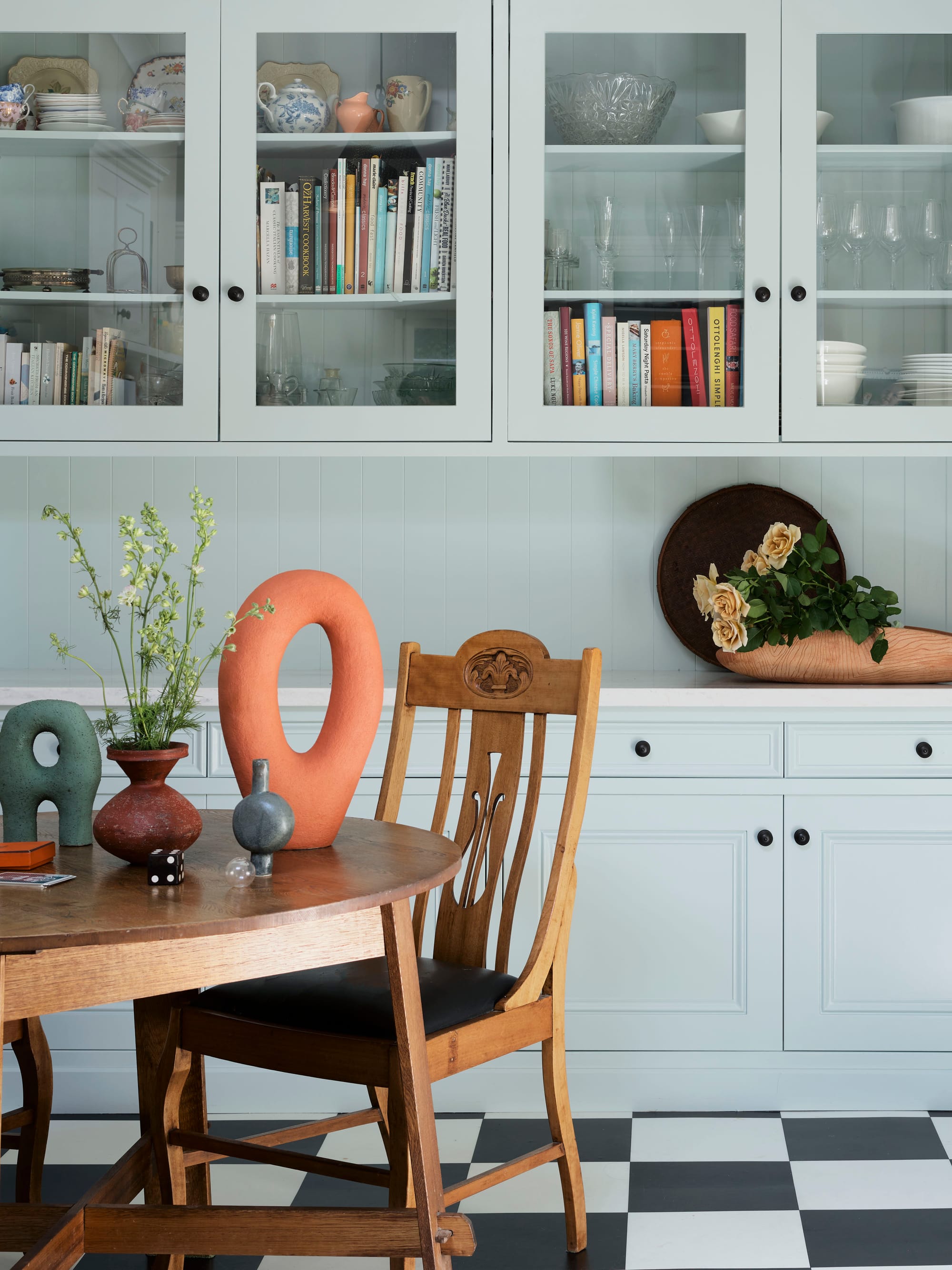 Ferris Street by Marylou Sobel Interior Design. Photography by Anson Smart. Kitchen and dining space with black and white checkered flooring, baby blue cabinets, and vintage dining table and chairs.