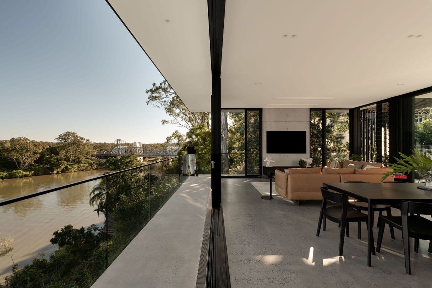 The River House, Indooroopilly by Sarah Waller Architecture. Photography by Alyne Media. Balcony with concrete flooring overlooking river below.
