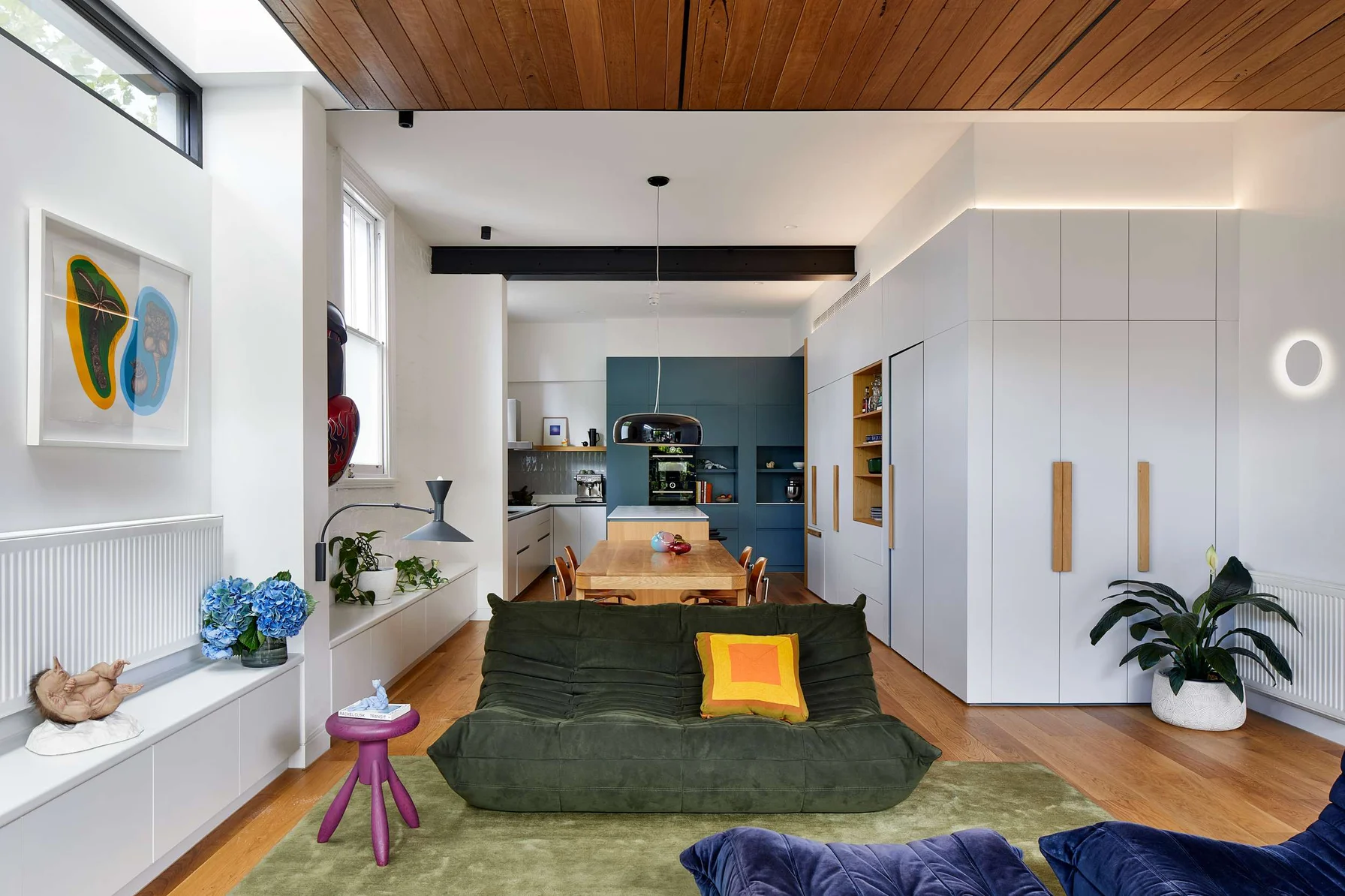 Art Forms by Hindley & Co Architecture & Interior Design. Photography by Tatjana Plitt. A contemporary open-plan living and kitchen area with bold colors, layered textures, and playful modern decor.
