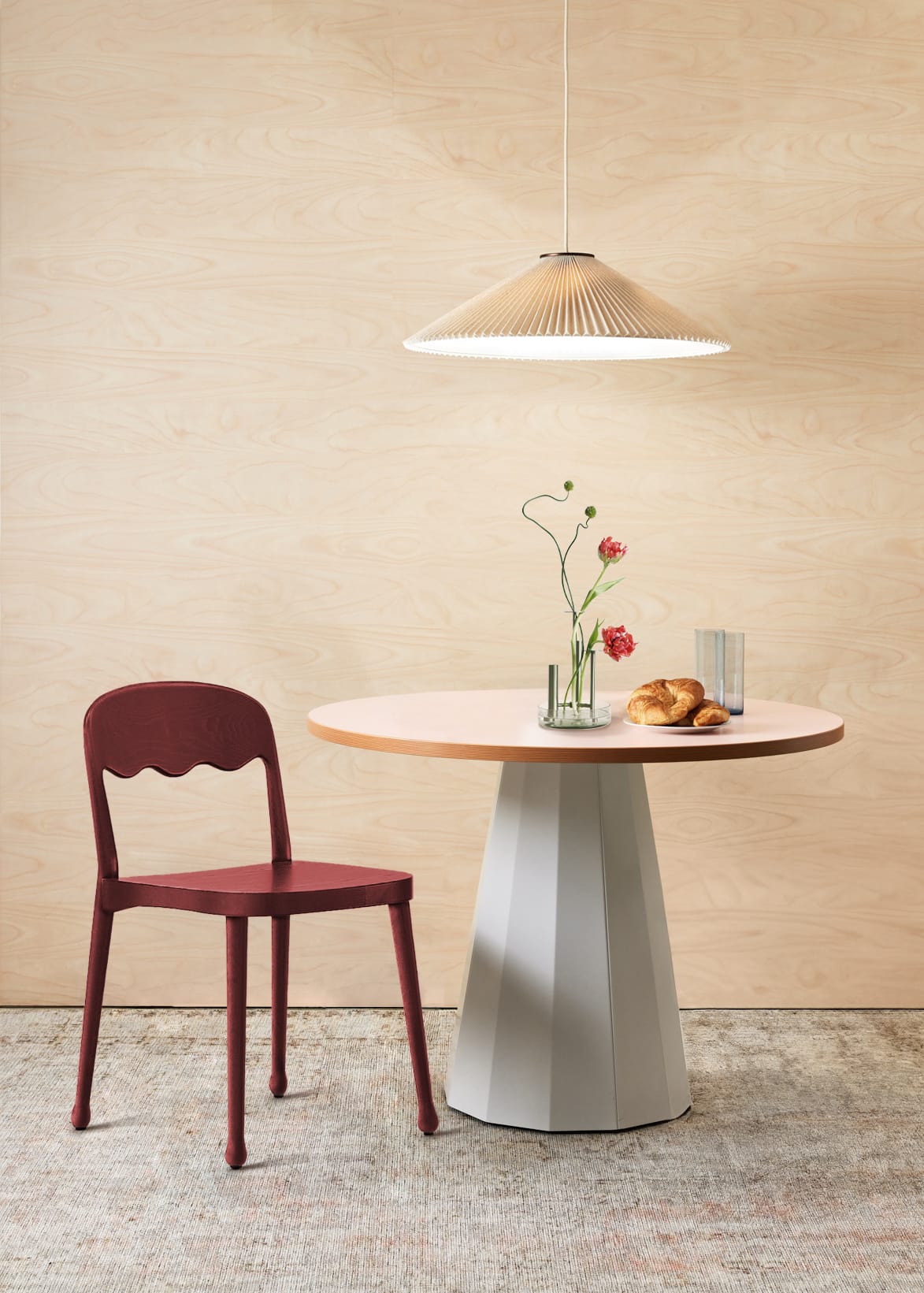 Billiani, Brand Partner for M&E Interiors. Maroon dining chair with scalloped back support detail at white and orange round dining table.