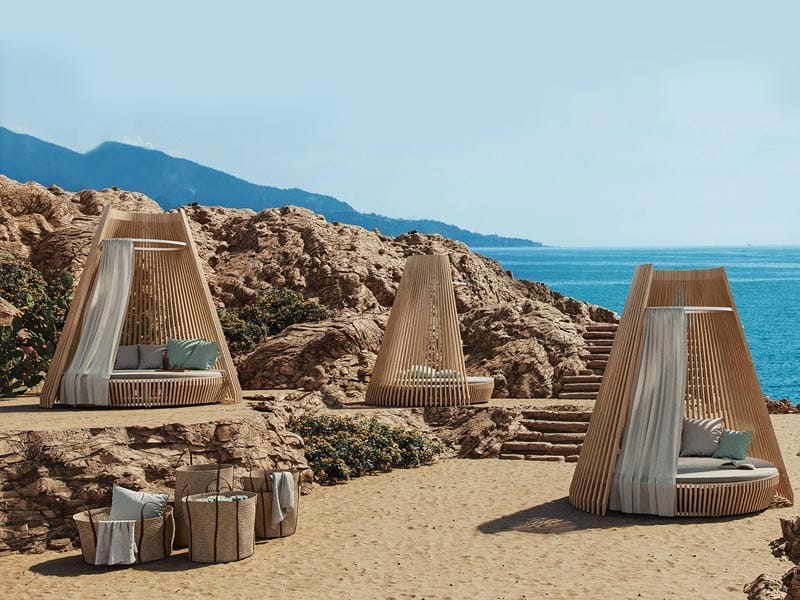 Ethimo, Brand Partner for M&E Interiors. Three timber day beds arranged on rocky hillside.