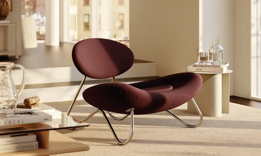 WOUD, Brand Partner for M&E Interiors. Abstract bean-shaped armchair in maroon with silver chrome supports.