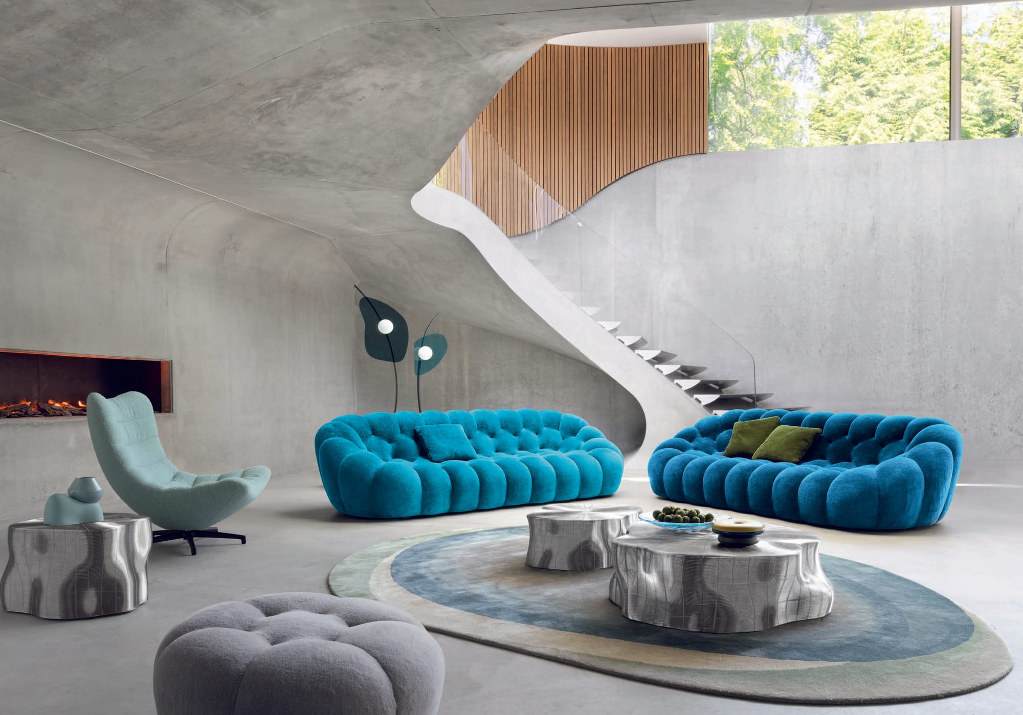 Bubble Collection by Roche Bobois. Image copyright of Roche Bobois. Blue bubble sofa with matching armchair, blue and white round coffee tables and floral floor rug. 