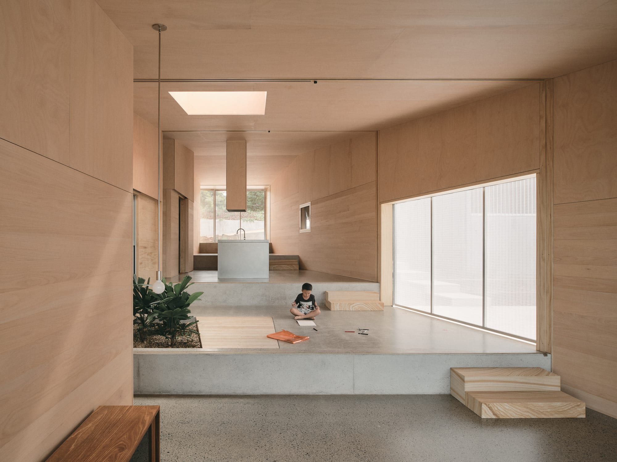 Mapleton House by Atelier Chen Hung. Photography by David Chatfield. Tiered open plan space with concrete floors, timber stairs, walls and ceilings.