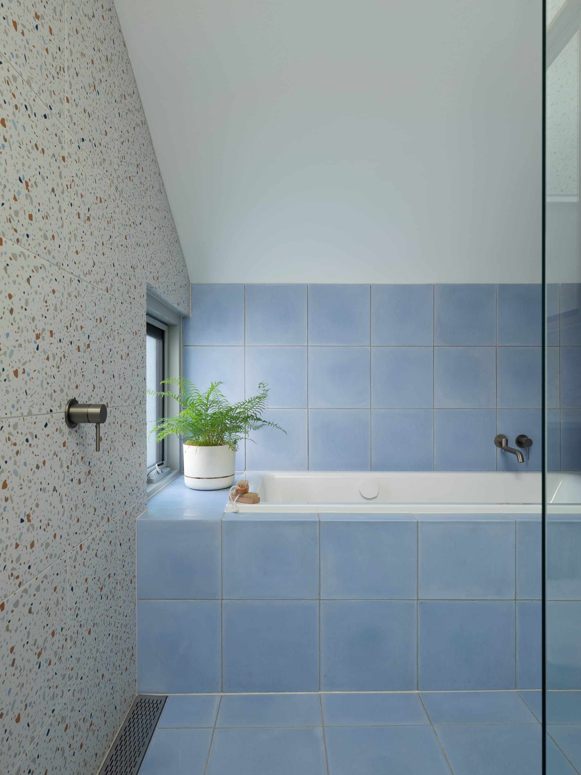 Merrilands by BIJL Architecture. Photography by Tom Ferguson. Bathroom with terrazzo wall tiles, power blue floor tiles and white bath.