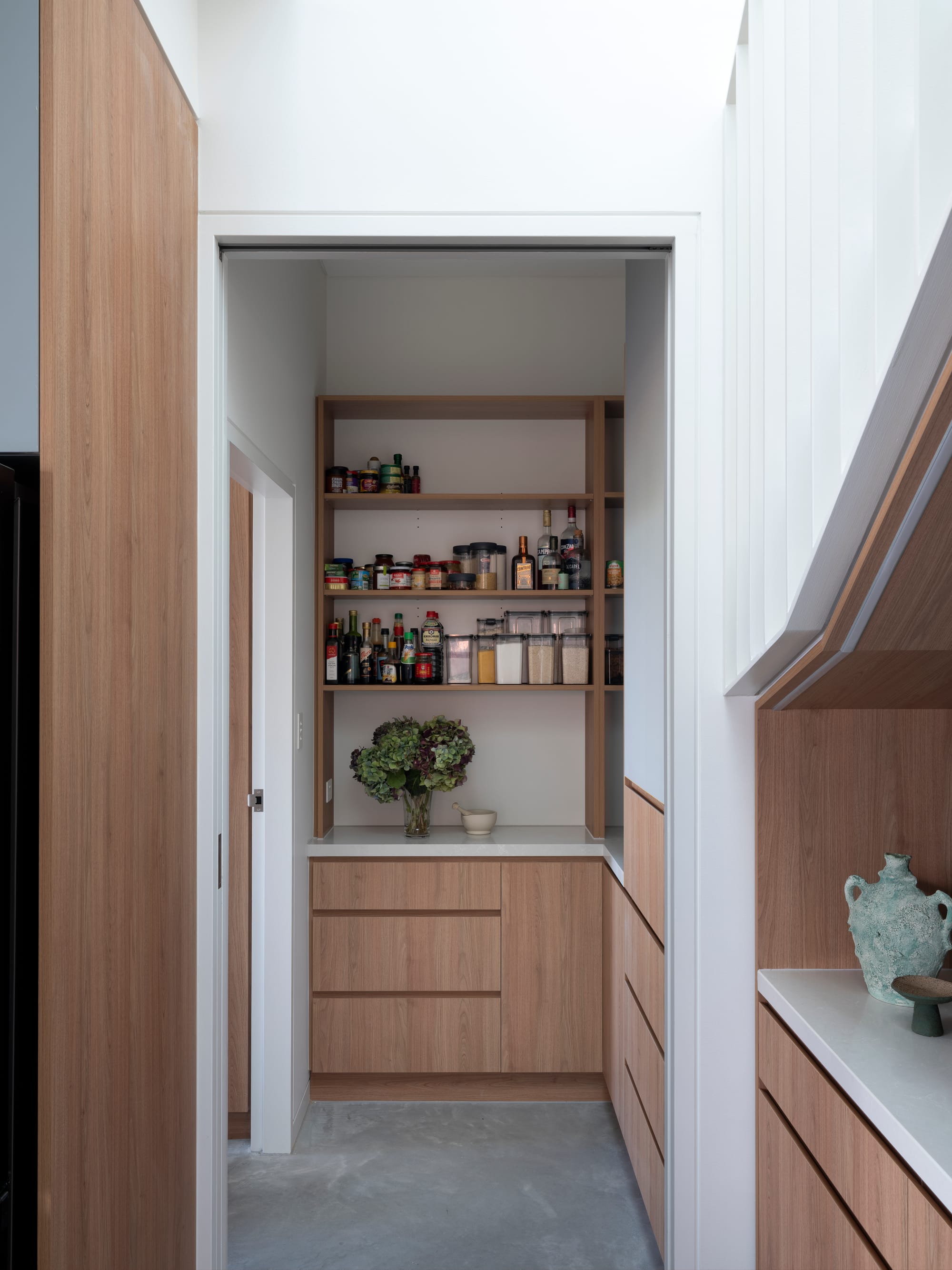 Merrilands by BIJL Architecture. Photography by Tom Ferguson. Scullery and pantry with concrete floors, open faced shelving and timber cabinetry.