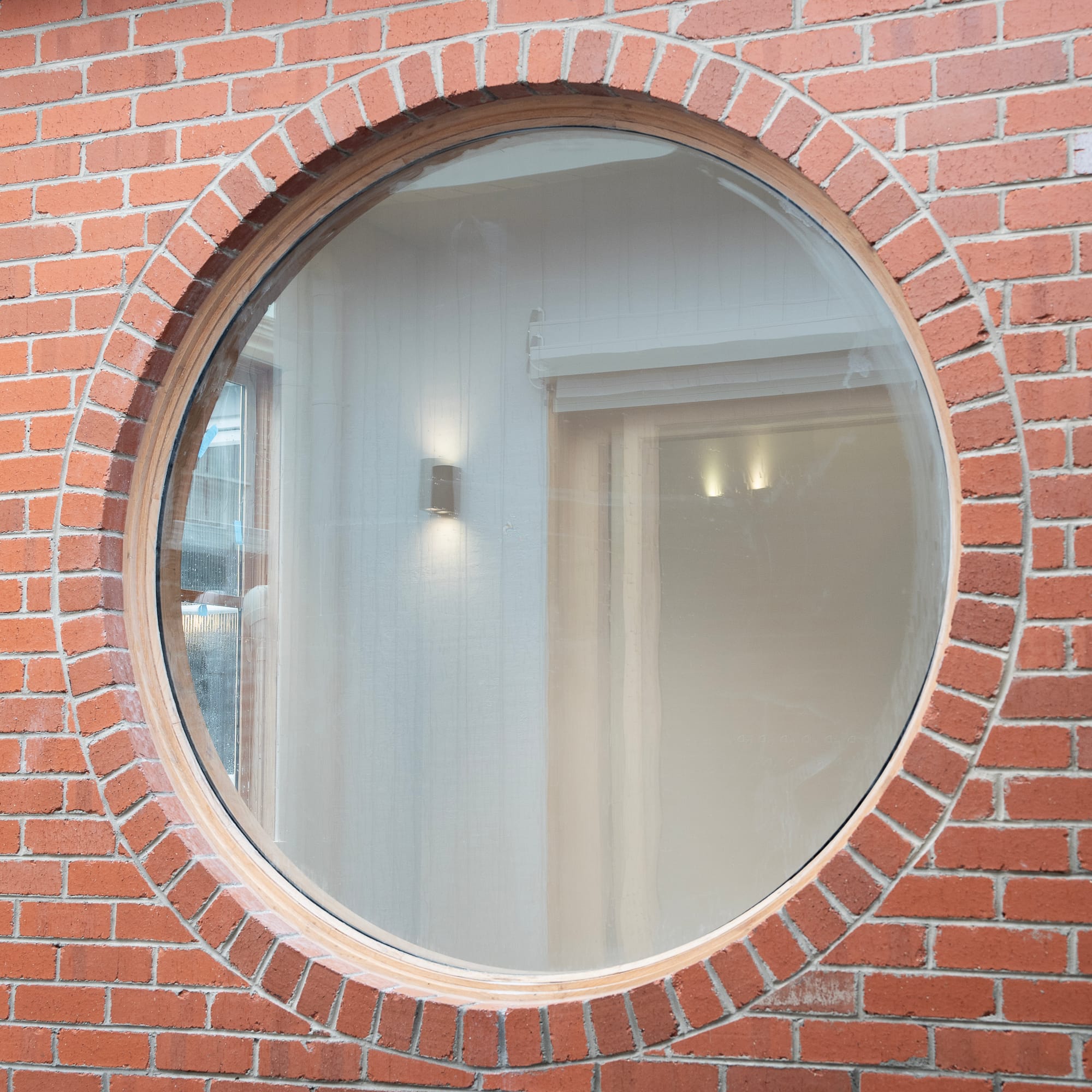 Murrumbeena by PREM.BUILT. Image copyright of Prem.Built. Feature wall lighting with round globe inlaid on organically curved stone made from white and pink striped material. 