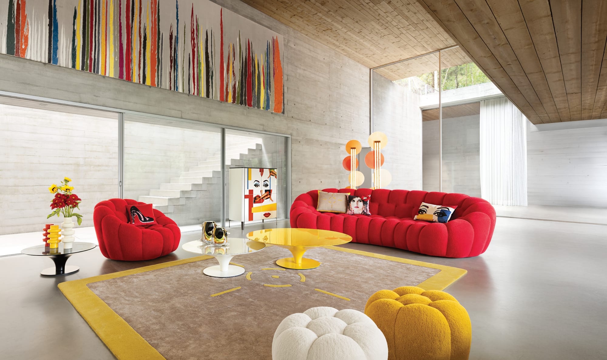 Bubble Collection by Roche Bobois. Image copyright of Roche Bobois. White bubble couch and matching armchairs in space with glass walls, yellow floors and colourful floor rug. 