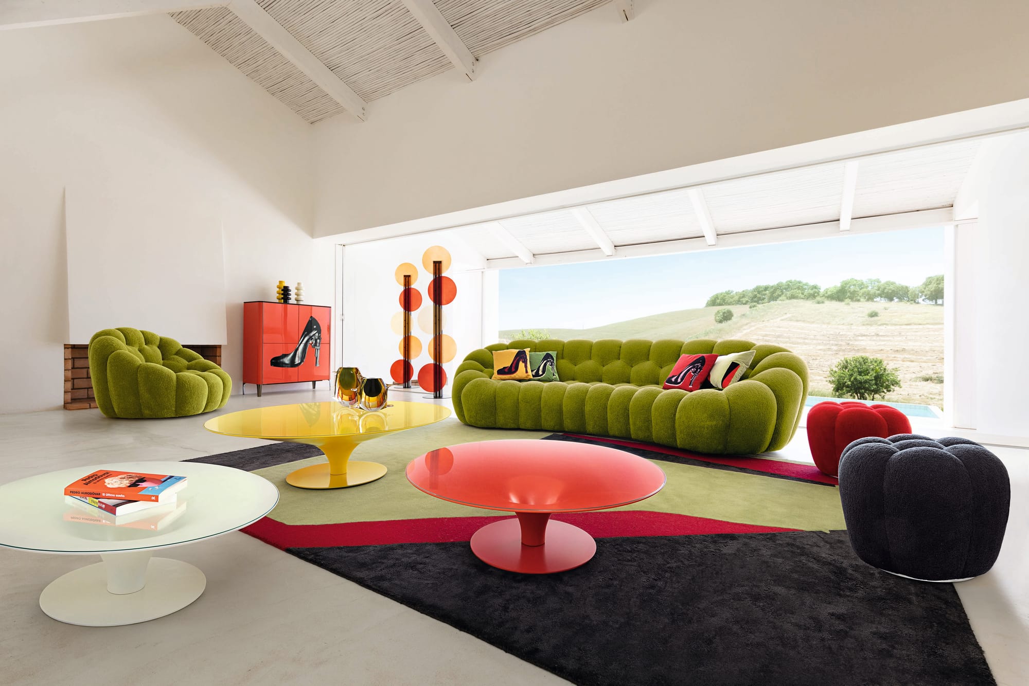 Bubble Collection by Roche Bobois. Image copyright of Roche Bobois. Green bubble sofa with matching armchair and bubble stools in black and red, with red, yellow and white coffee tables. 