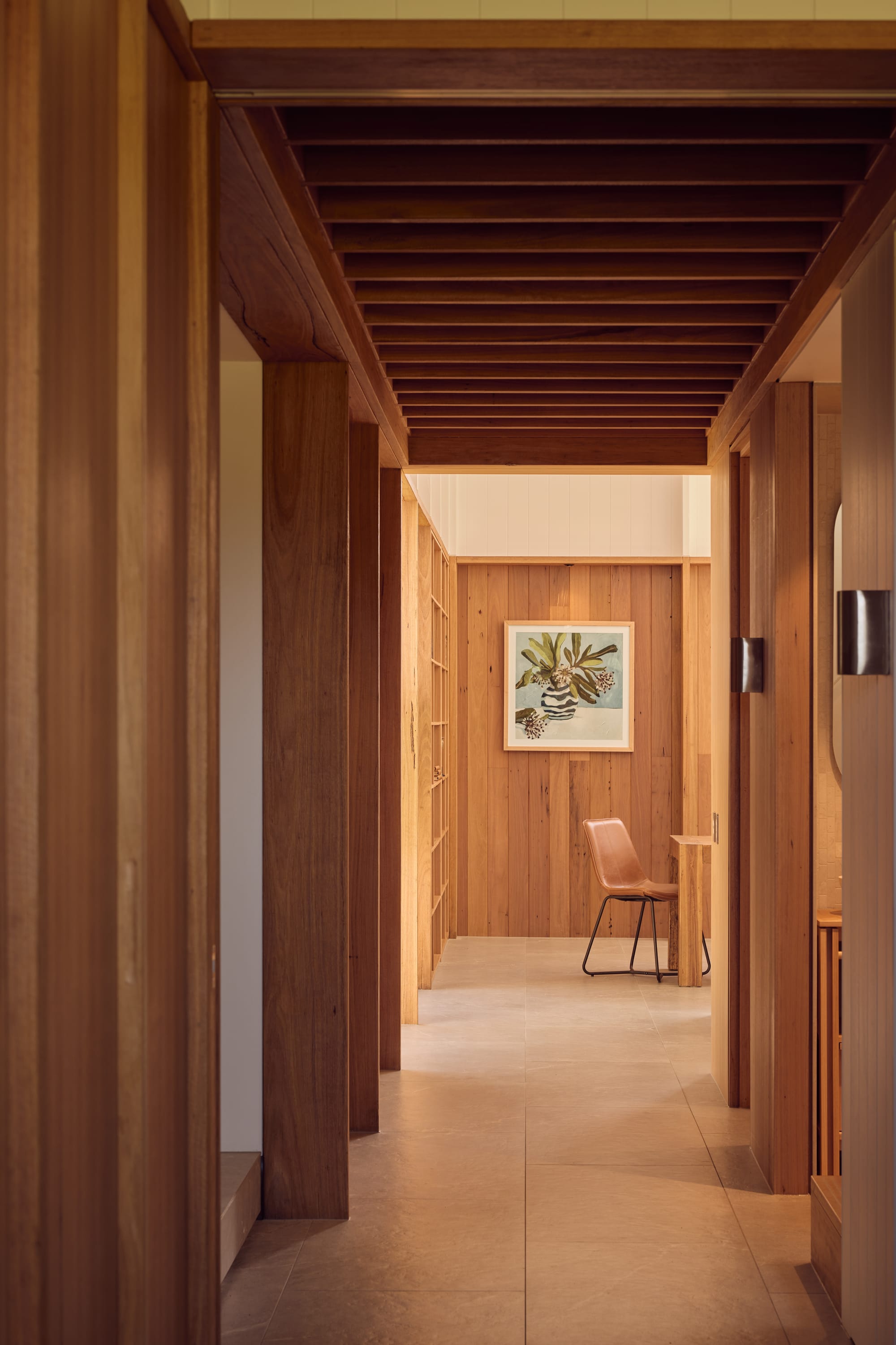 Binnum Homestead by Alexandra Buchanan Architecture. Photography by Cieran Murphy. Hallway with timber doorways and walls, tiled floor and warm lighting.