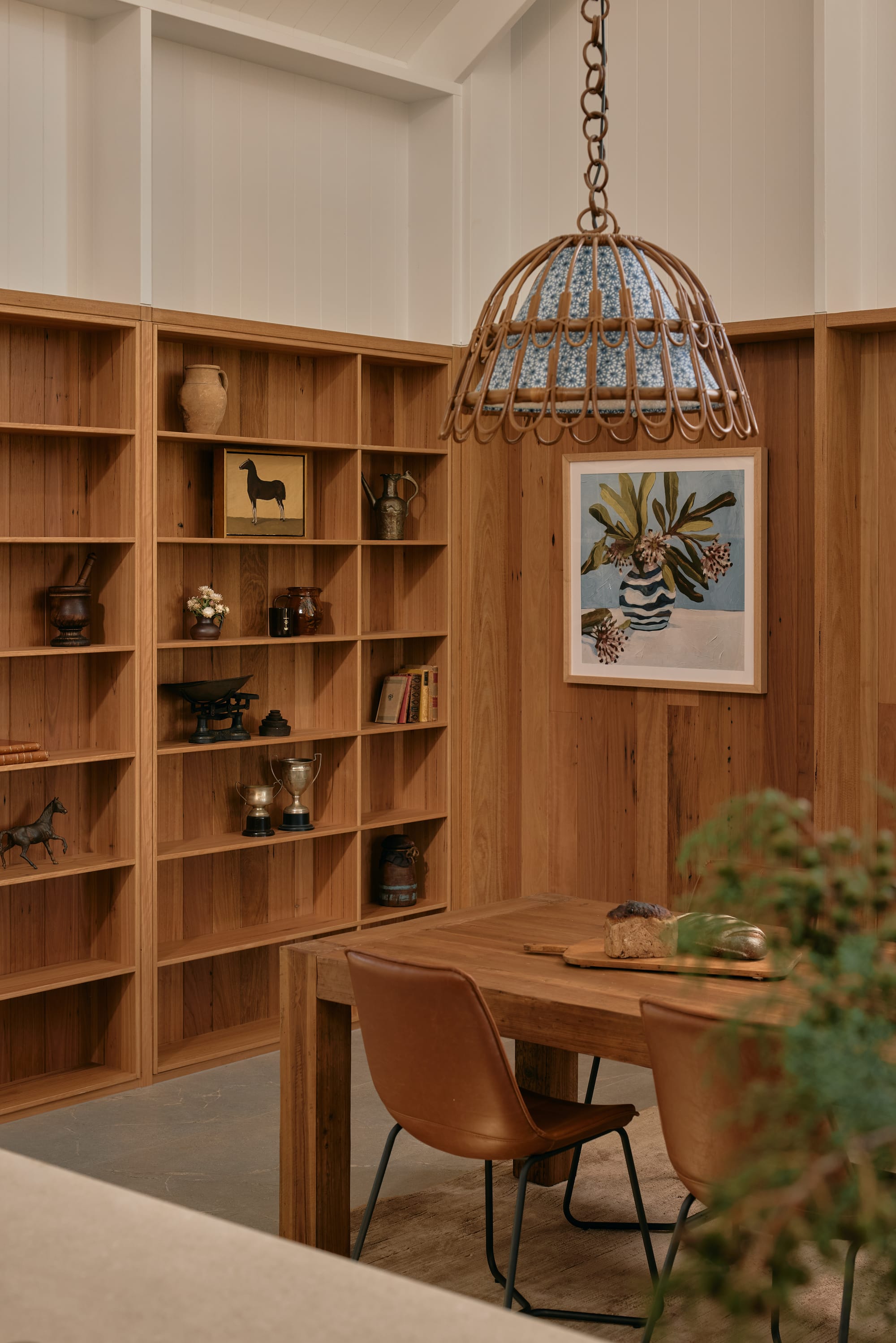 Binnum Homestead by Alexandra Buchanan Architecture. Photography by Cieran Murphy. Timber dining table with large pendant light above, and timber bookshelf to the left.