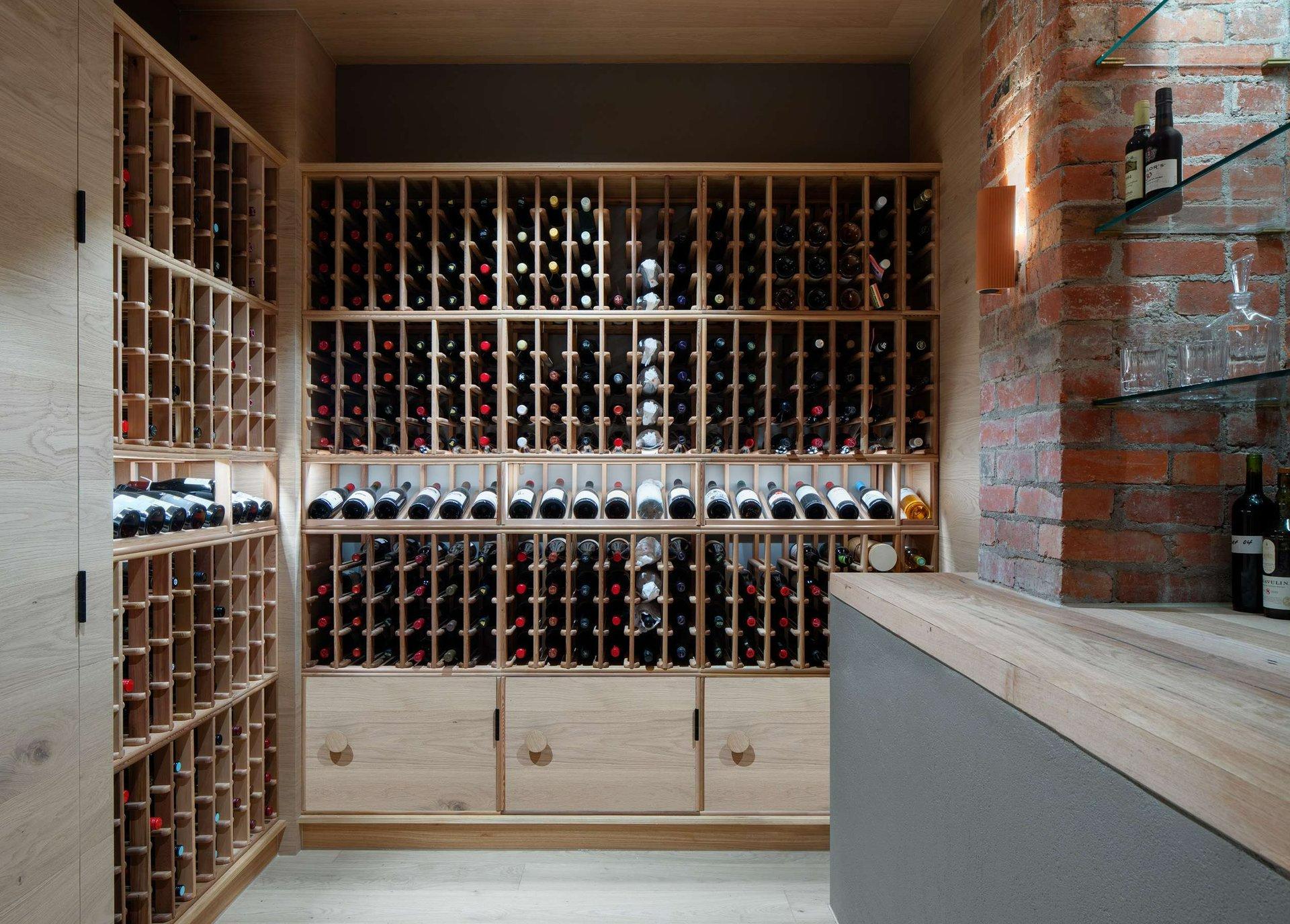 South Terrace Renovation by Chan Architecture. Photography by Tatjana Plitt. Wine cellar with timber cabinetry and storage, timber countertop and red brick walls.