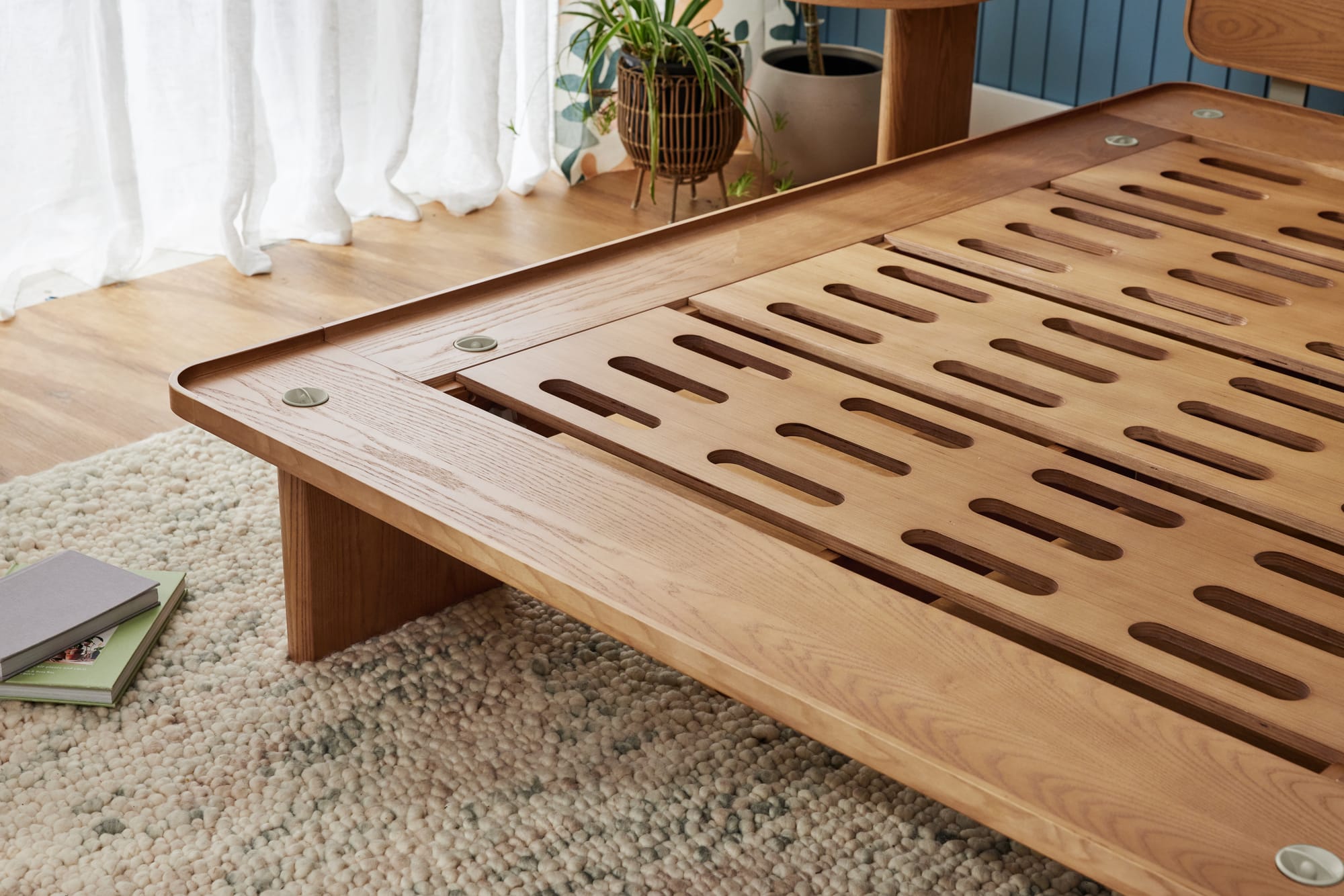 Kirribilli Bed Frame by Koala. Exposed timber bed frame with clean construction and design, in room with timber floors, white sheers and jute rug.