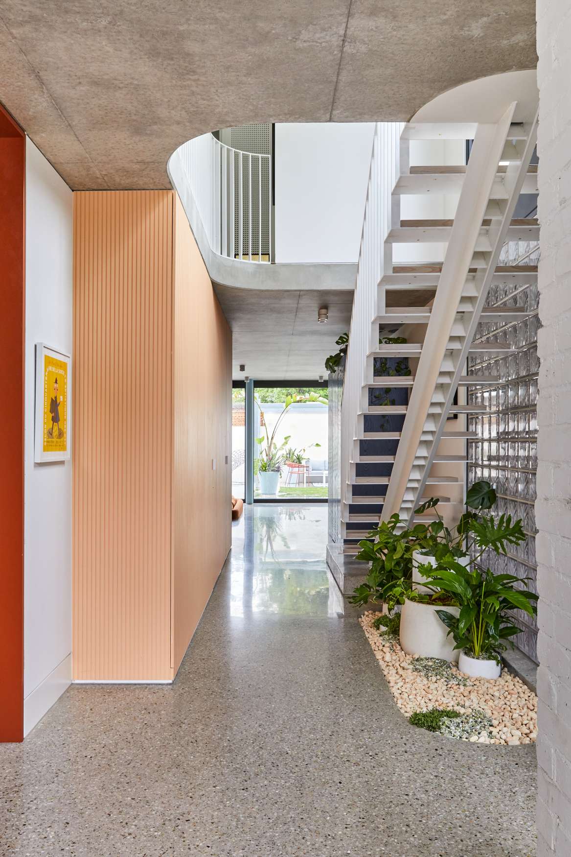 Park St by SGKS ARCH. Photography by Tania Lee. Hallway with concrete floors, peach walls and metal staircase.