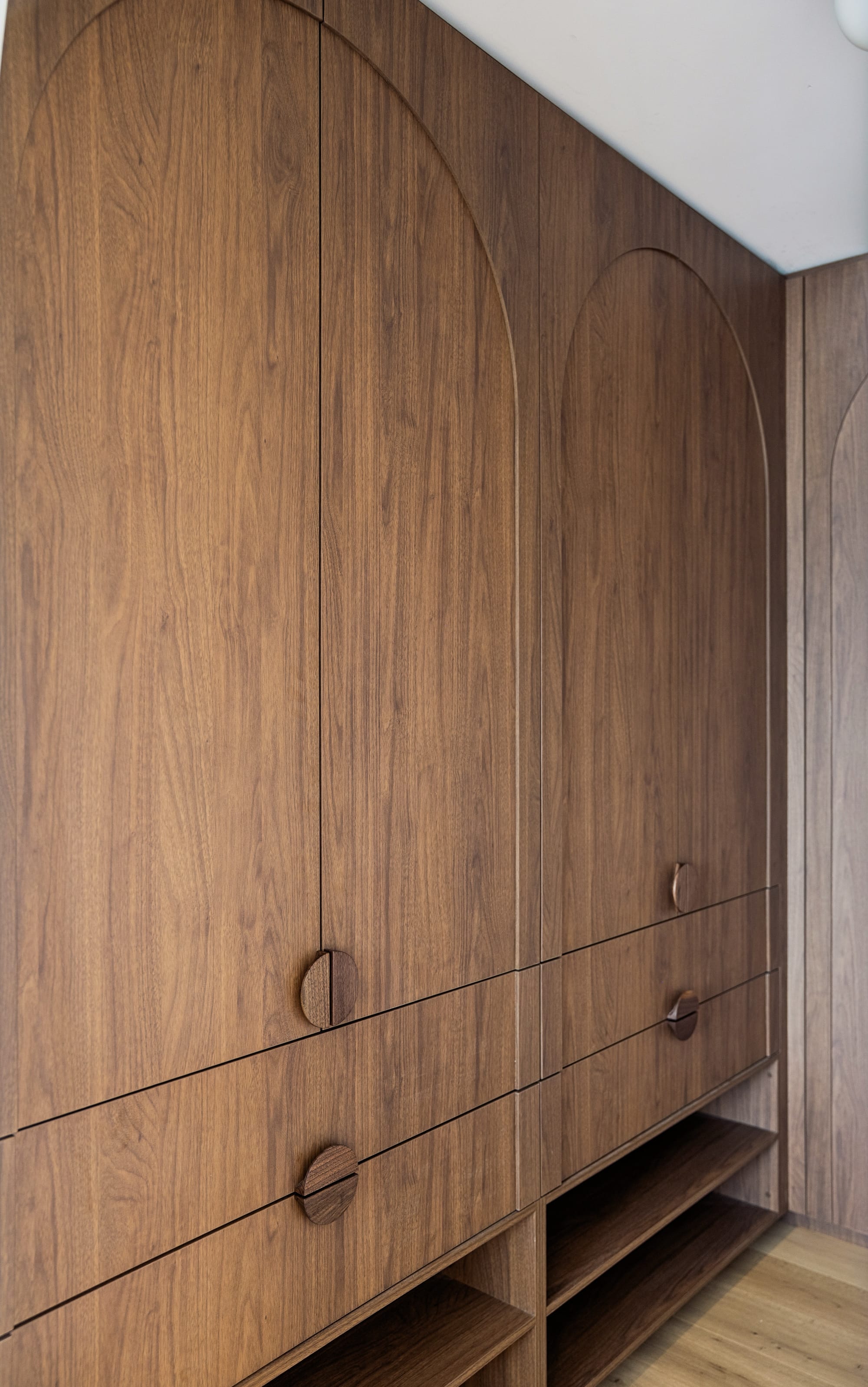 Chardonnay Court House by Studio MDM. Photography by Focl Media. Timber cabinetry with arched door details, round handles and open storage on bottom. 