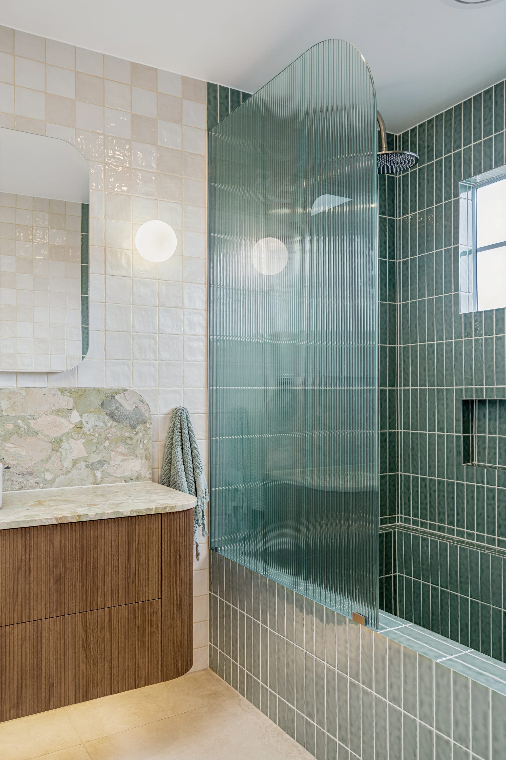 Chardonnay Court House by Studio MDM. Photography by Focl Media. Bathroom with fluted timber cabinetry, flute grass shower screen and show bath with green subway tiles. 