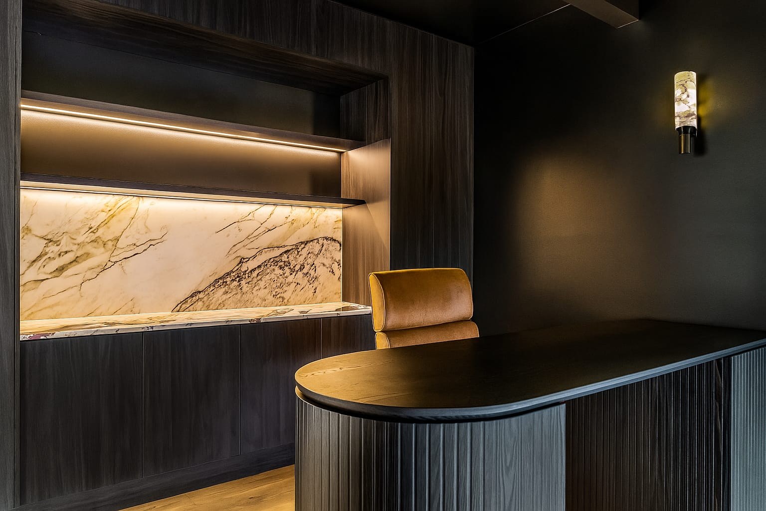 Chardonnay Court House by Studio MDM. Photography by Focl Media. Dark office space with curved black timber clad desk, tan leather office chair and cabinetry with beige stone splashback. 