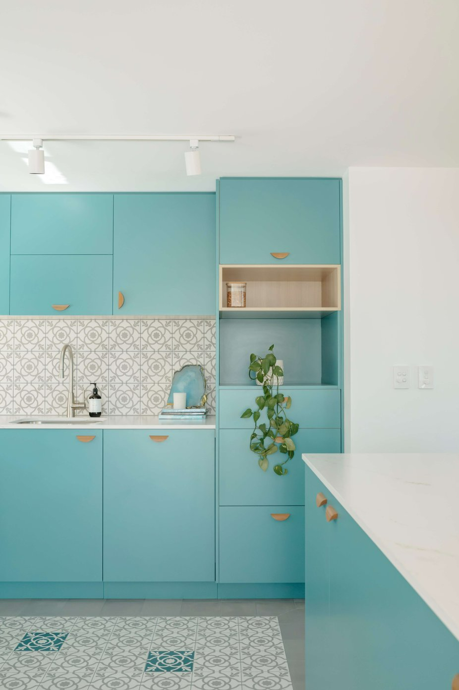 Westleigh Wonder by Nathalie Scipioni Architects. Photography by Alexandra Adoncello. Kitchen with aquamarine cabinetry, patterned white, grey and blue floor tiles and splashback.