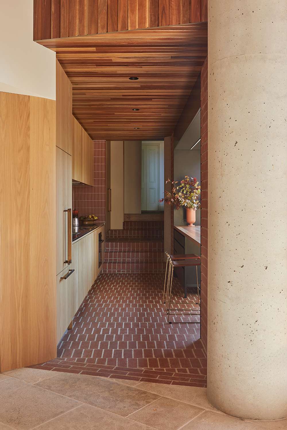 An interior image of a warm kitchen with terracotta and timber.