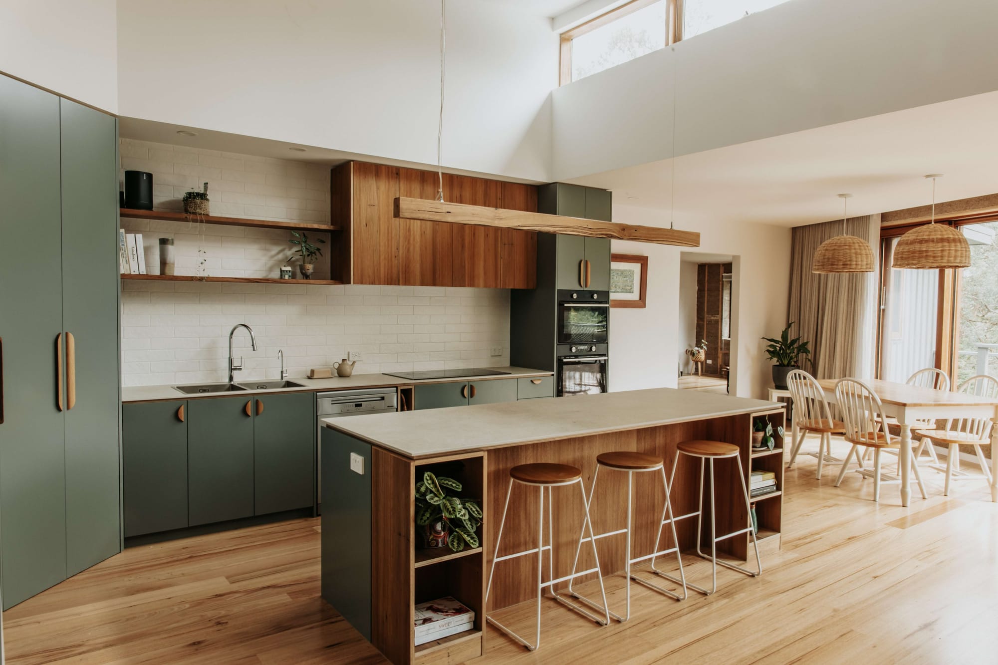 An interior shot of the kitchen at Hemp Home showing the green cabinetry and timber veneer.