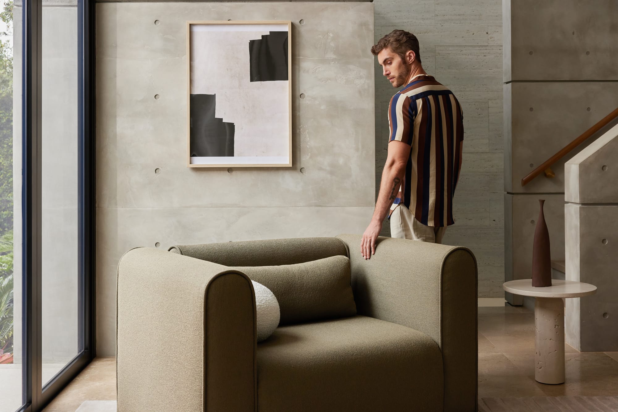 Koala's Bangalow Modular Sofa Bed in Green Wattle with a man walking behind the single chair.