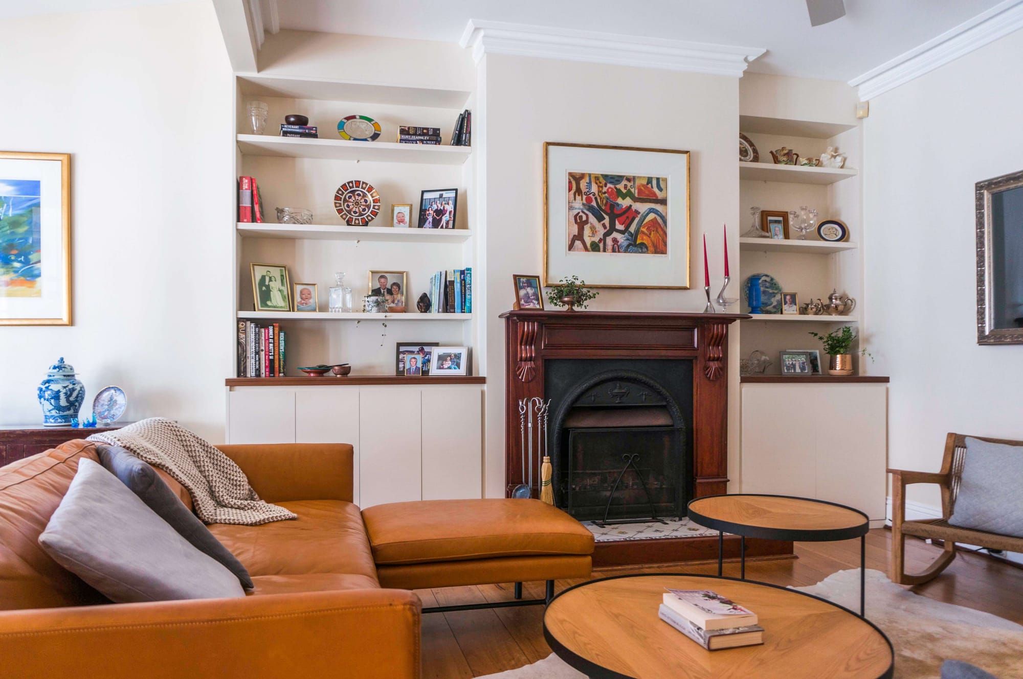 Balmain House by Nx Studio. Photograohy by Gretchen Chappelle. Living space with timber fireplace, leather couch, timber coffee tables and integrated shelving. 