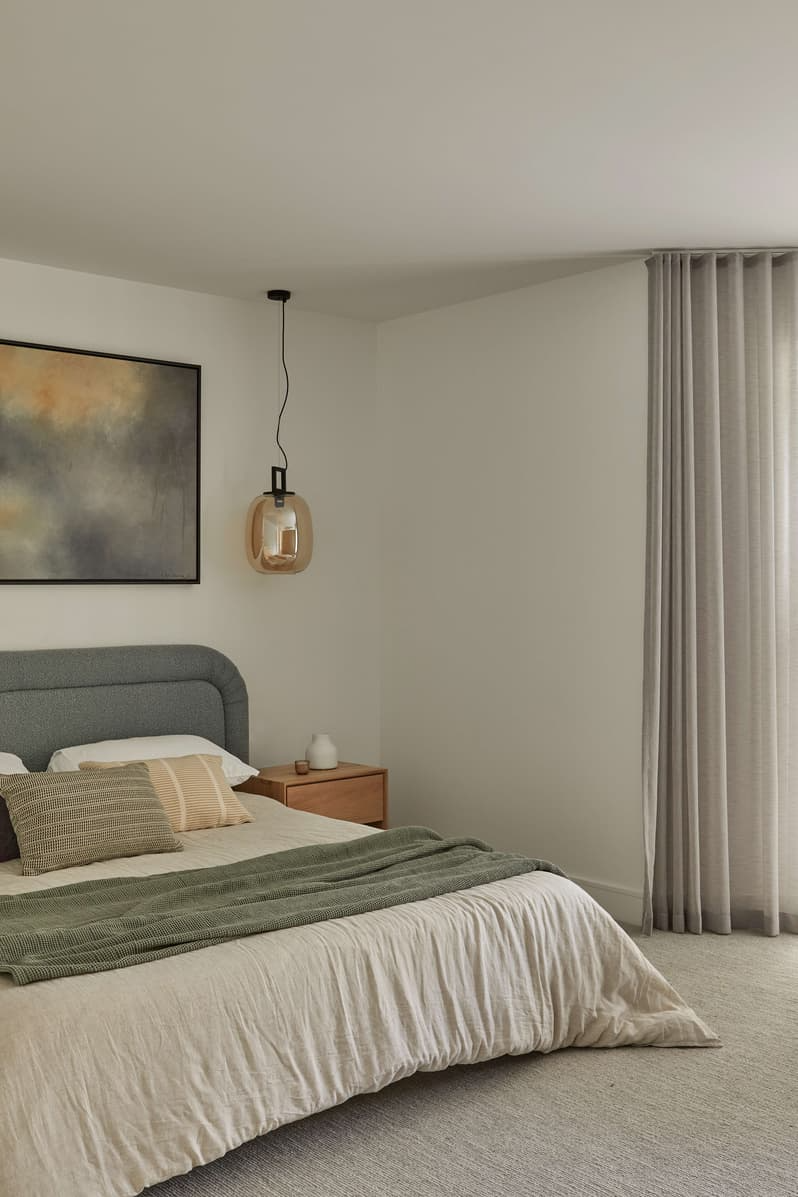 Horizon Home by Samuel Architecture. Photography by Dave Kulesza. Bedroom with grey fabric headboard, grey carpets, sage throw rug and timber bedside table. 