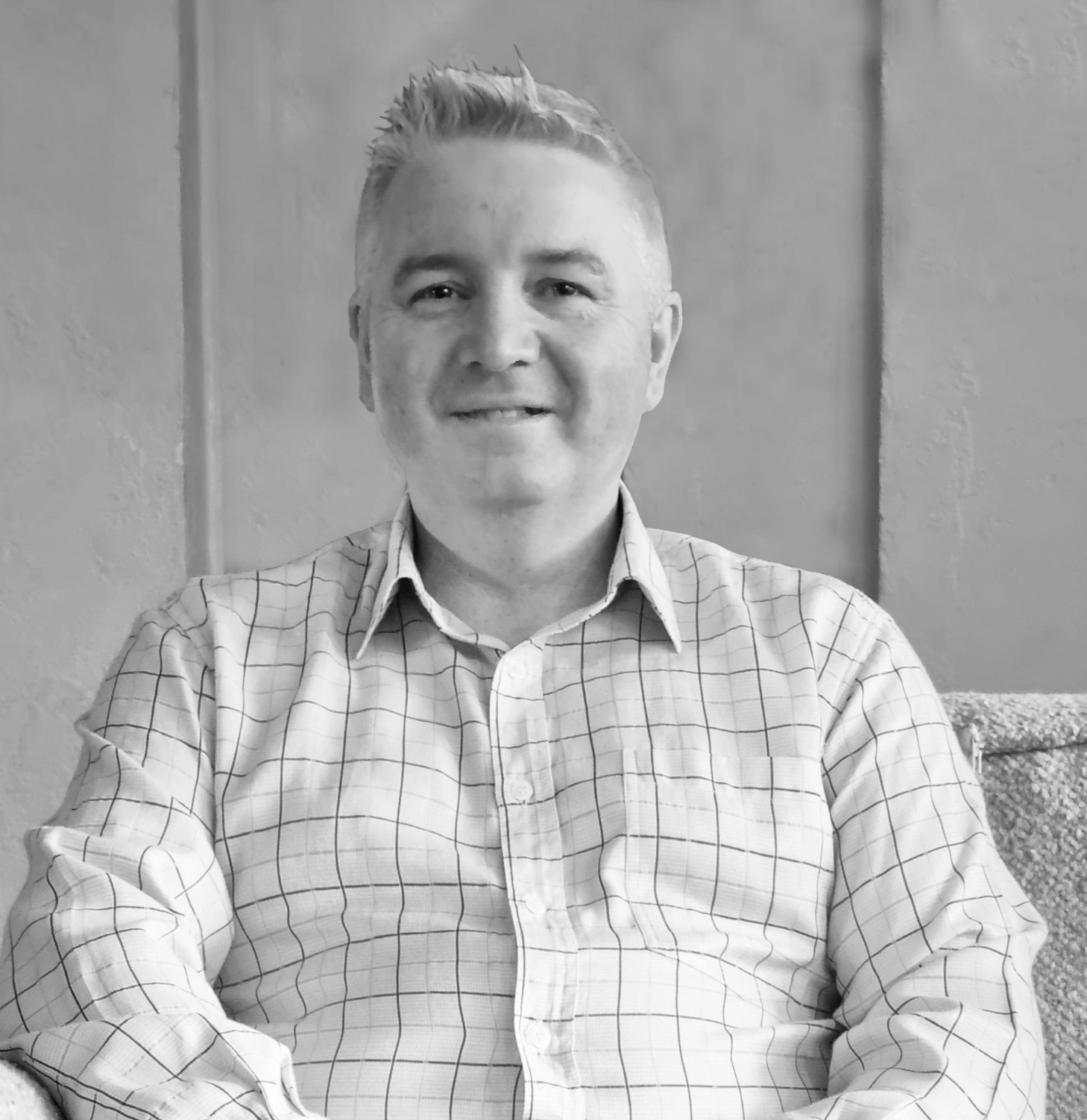 Steven Pooley of Saru Design.  Black and white image if man in checked shirt smiling. 
