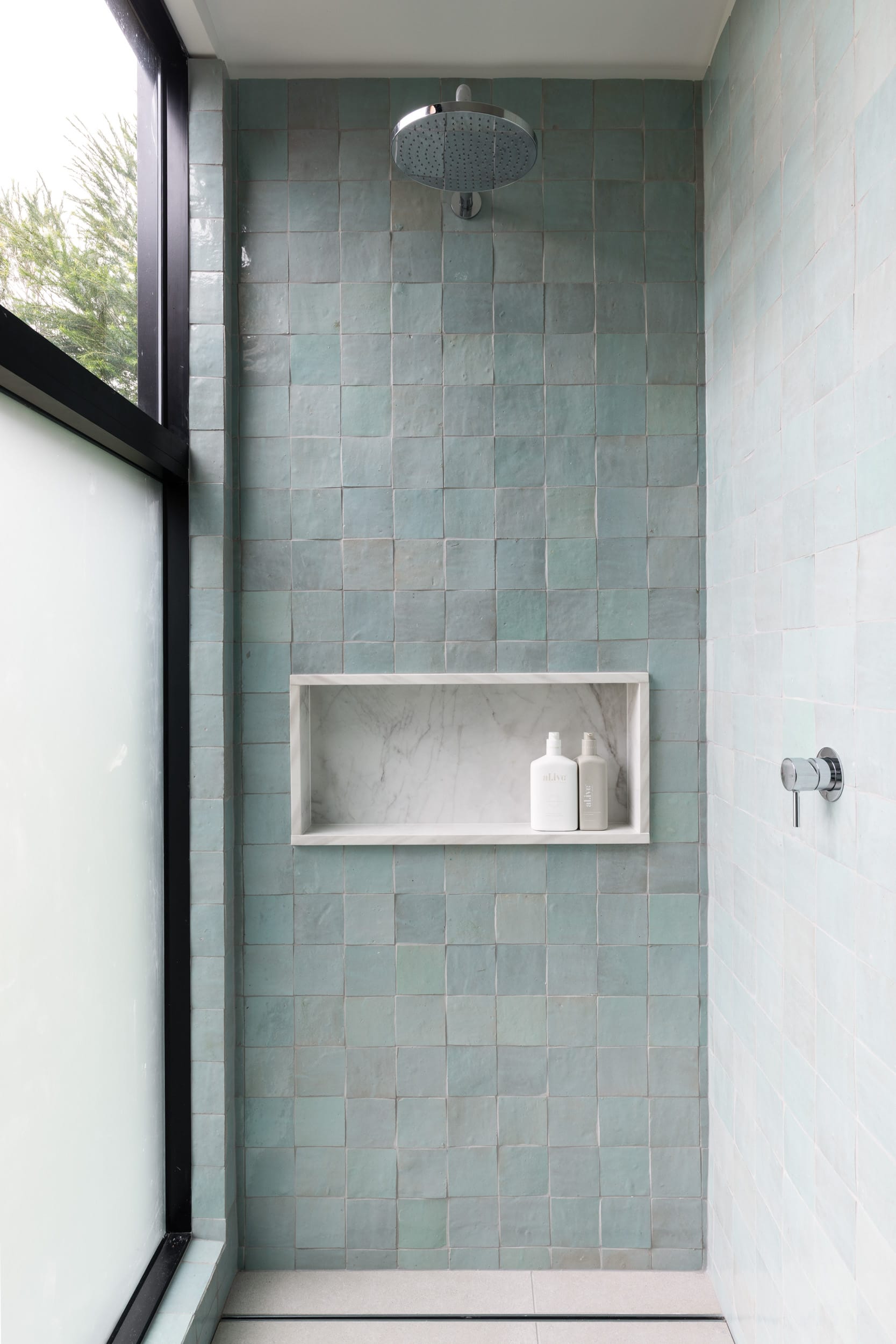 Bawley Point by Watershed Architects. Photography by Simon Whitbread. Shower with textured mint green tiled walls, frosted glass window, white stone integrated wall shelving and silver fixtures. 