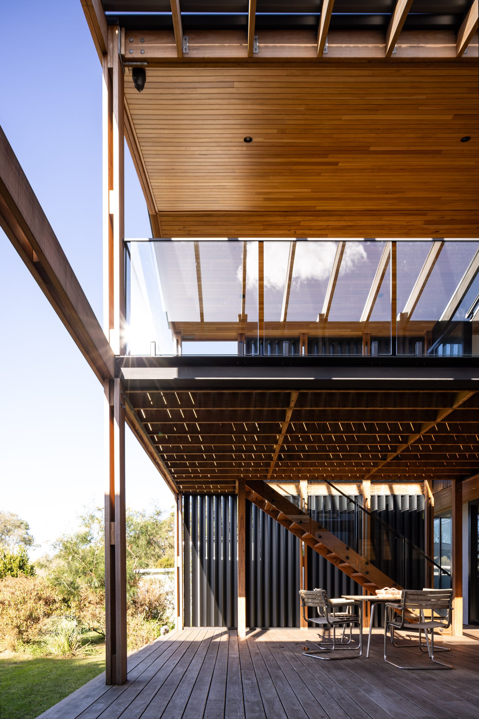 Bawley Point by Watershed Architects. Photography by Simon Whitbread. Timber deck with exposed timber clad ceiling, black timber cladding and aluminum dining table. 