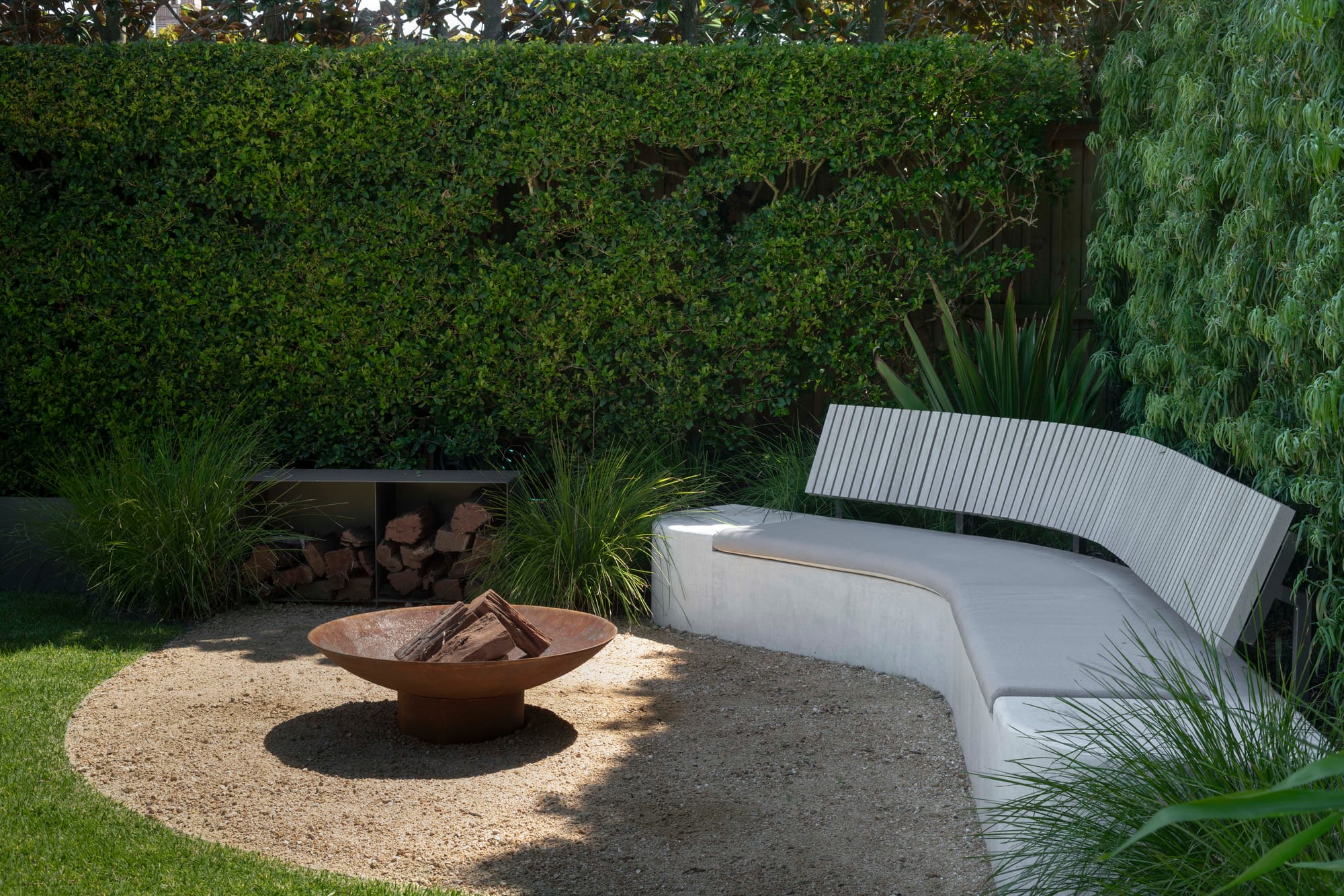 fire pit with logs and grey seating area 