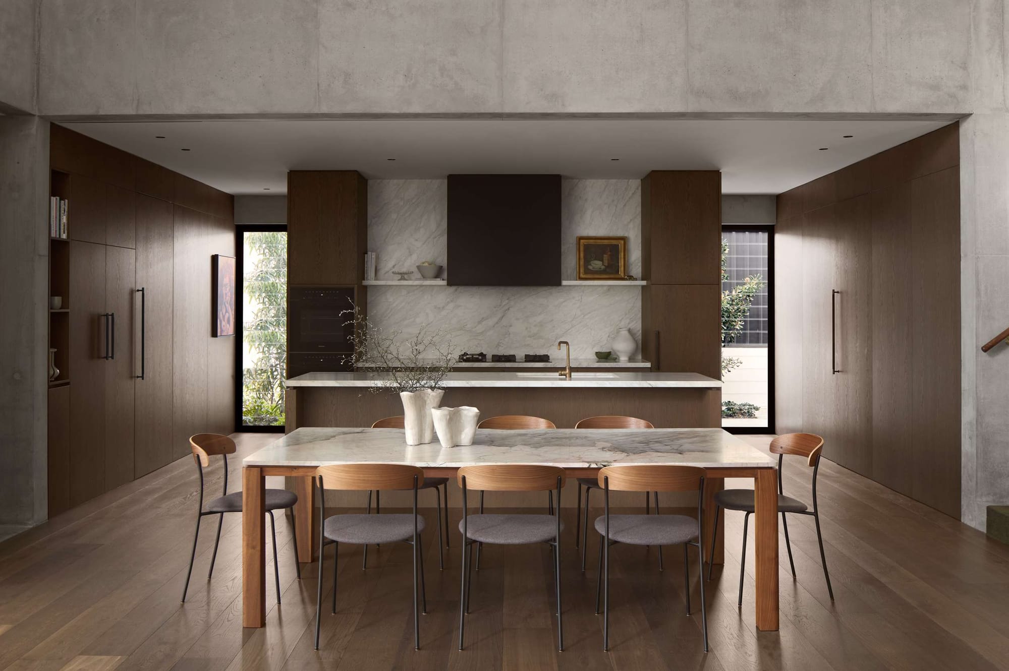 Minimalist kitchen and dining space with marble island, timber joinery, and open-plan layout in a high-end Perth renovation