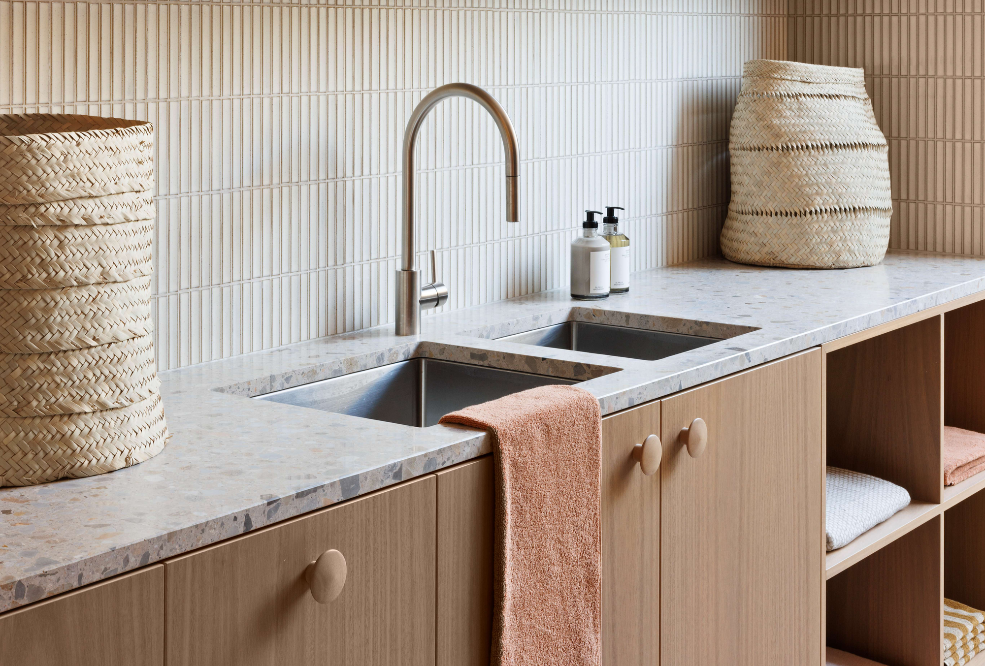 Laundry with double sink, terrazzo benchtop, timber cabinetry, and textured tile splashback in a contemporary Melbourne renovation