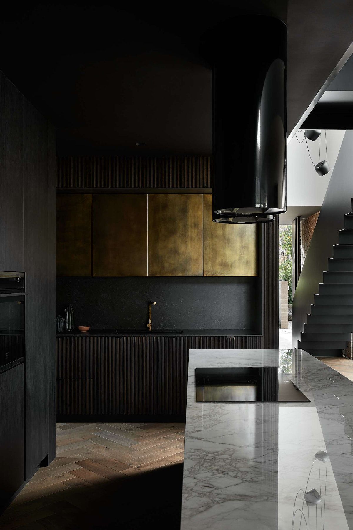 Das Studio interior of a kitchen with brass and marble elements