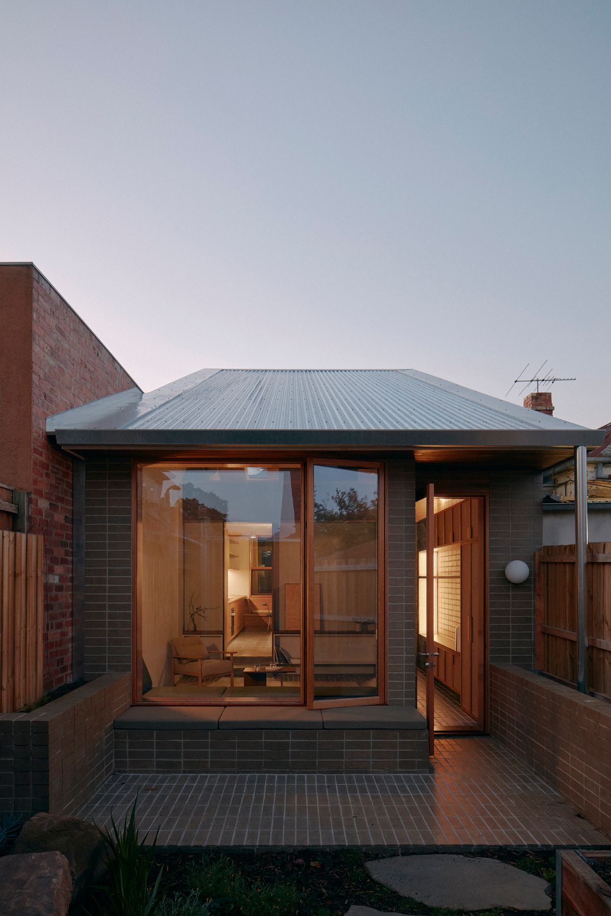 Brunswick by Placement Studio showing house at twilight with warm light in interior