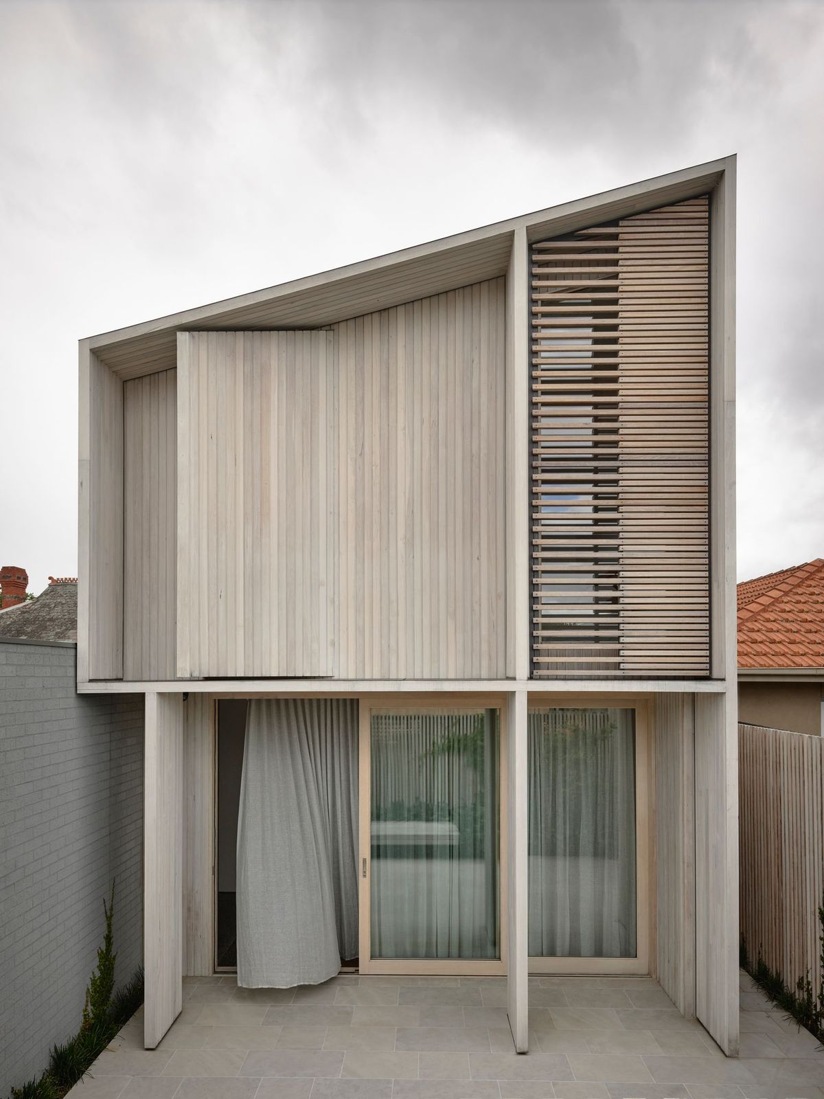 Silvertop House by Tom Robertson Architects. Exterior rear facade shrouded in silvertop ash cladding