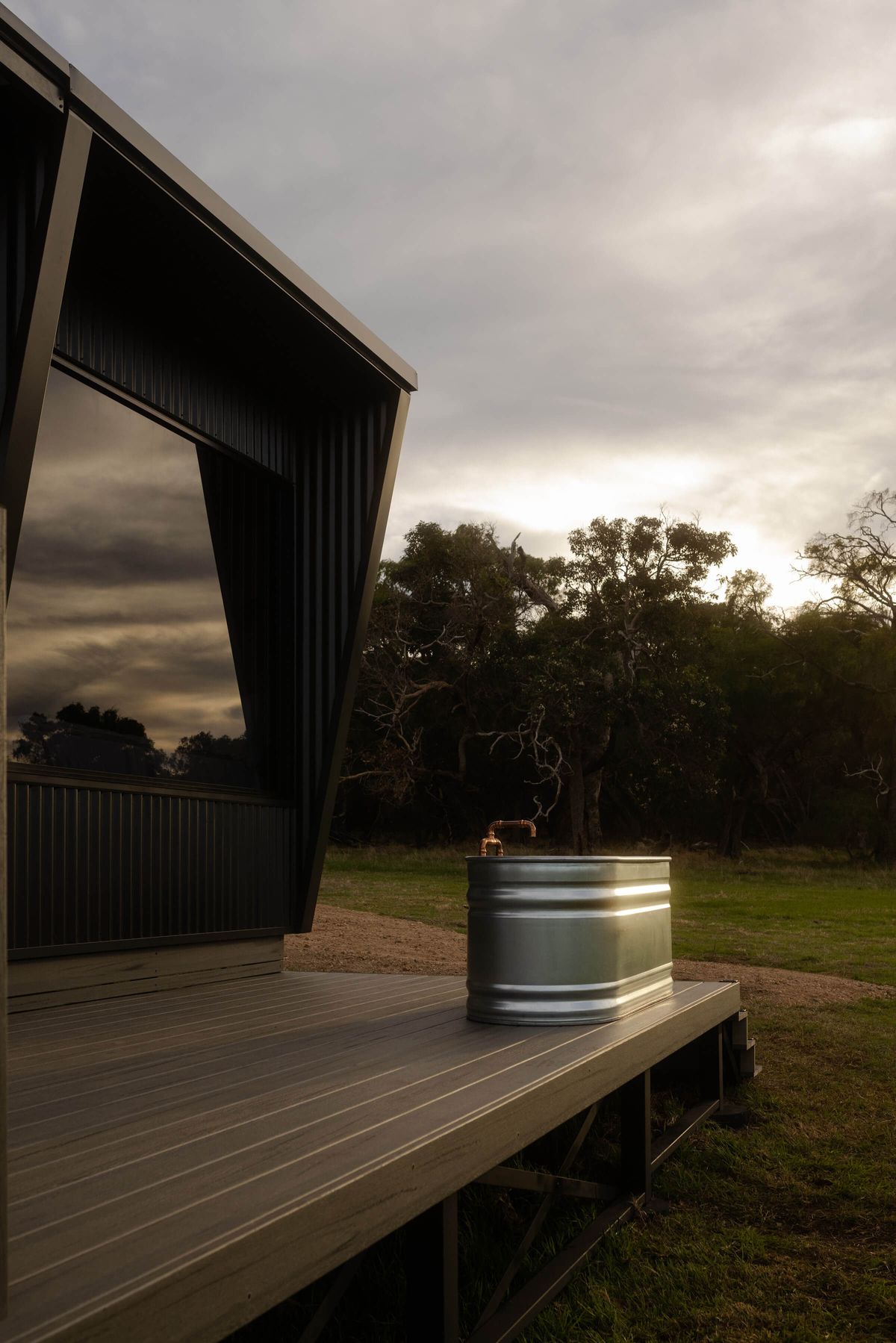 Heyscape Tiny Cabins. Cabin deck with outdoor soaking tub looking out to surrounding landscape. 