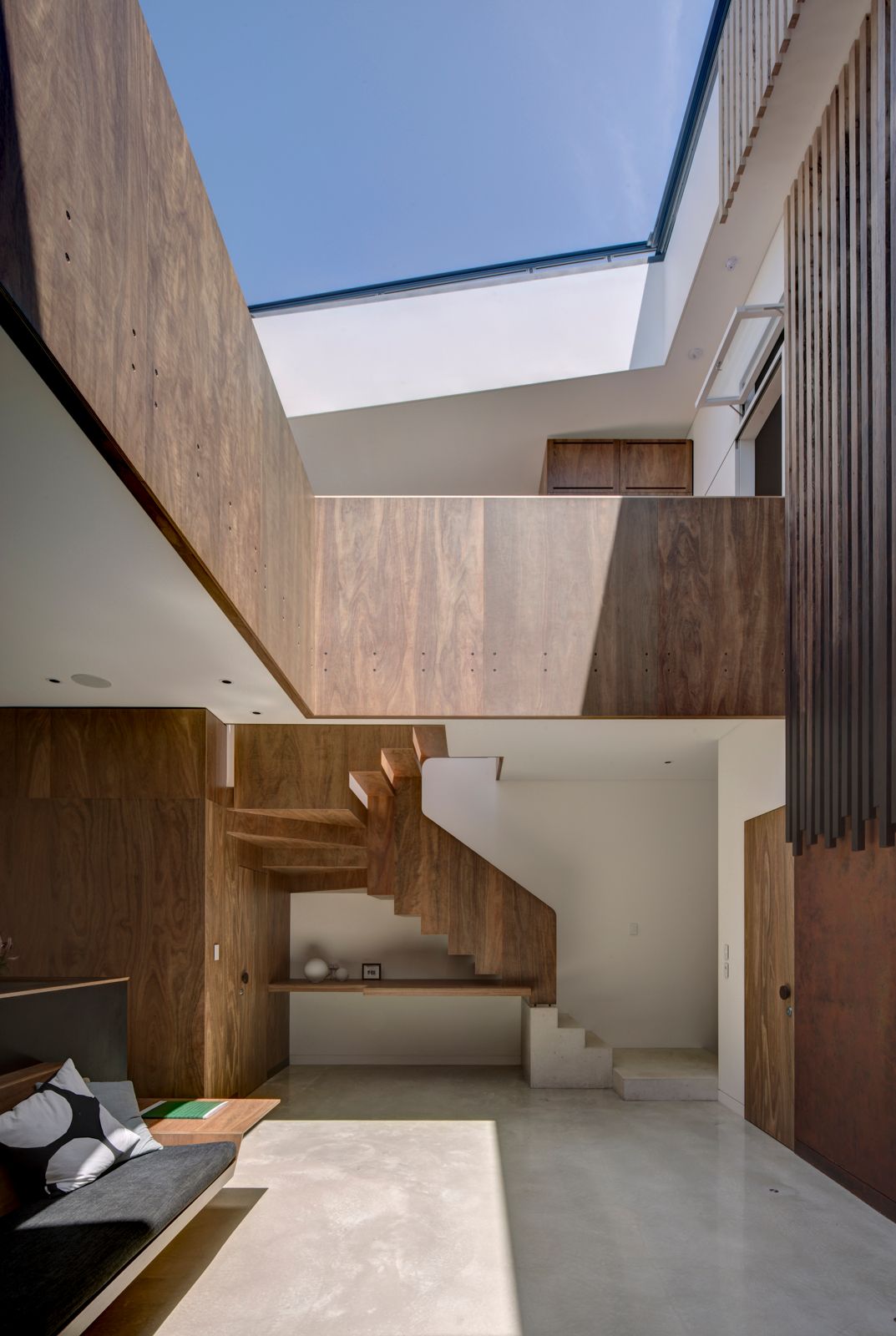 Sky House by Marra+Yeh Architects showing interior view of feature timber and concrete staircase